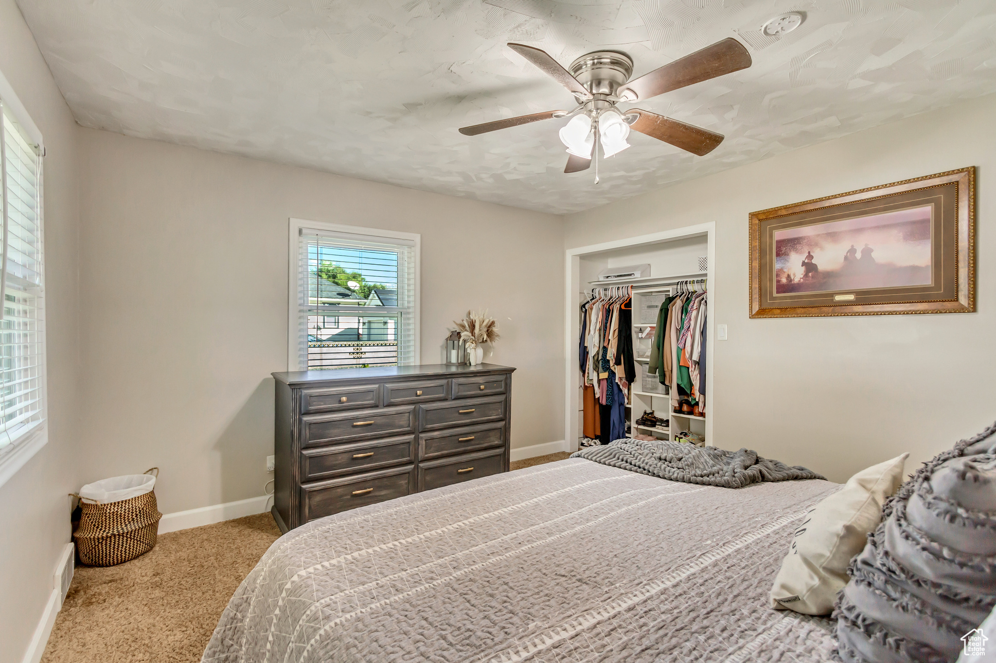 Bedroom featuring light carpet, ceiling fan, and a closet