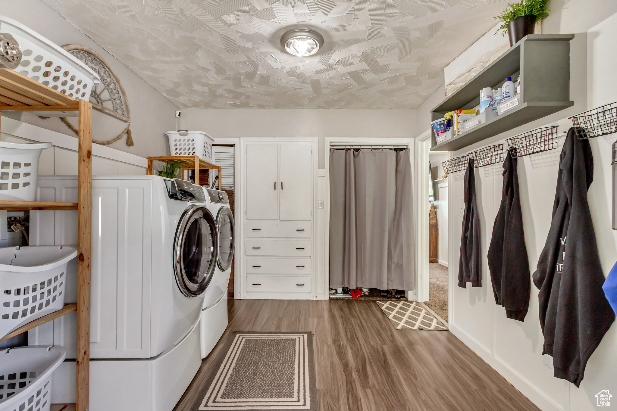 Laundry area with separate washer and dryer and dark wood-type flooring