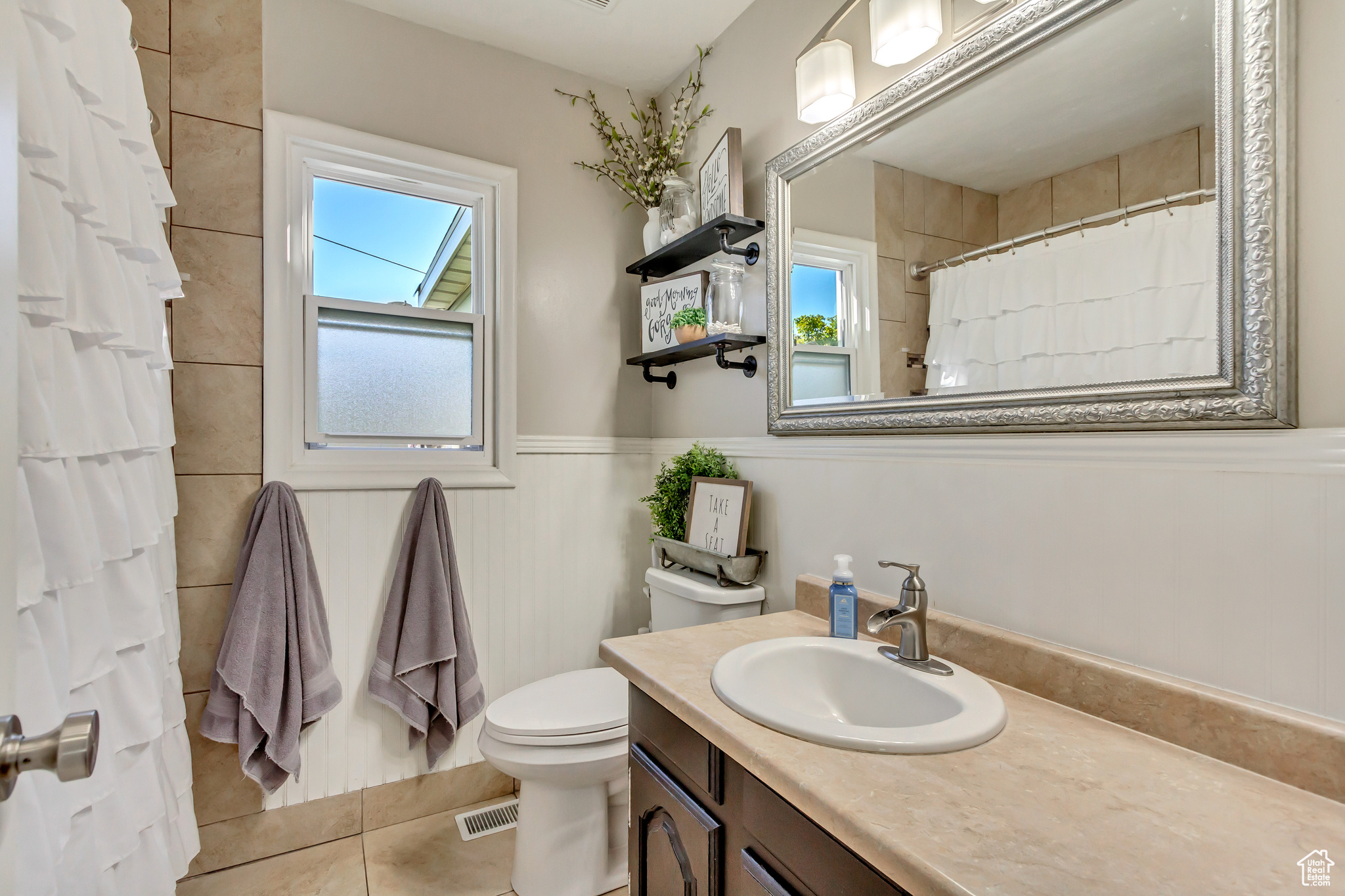 Bathroom with tile patterned flooring, curtained shower, vanity, and toilet