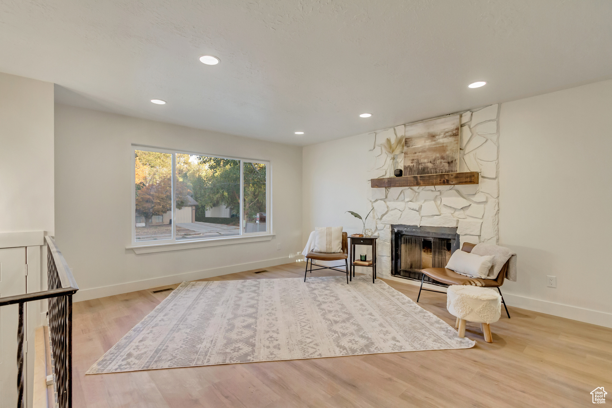 Living area with light wood-type flooring and a fireplace