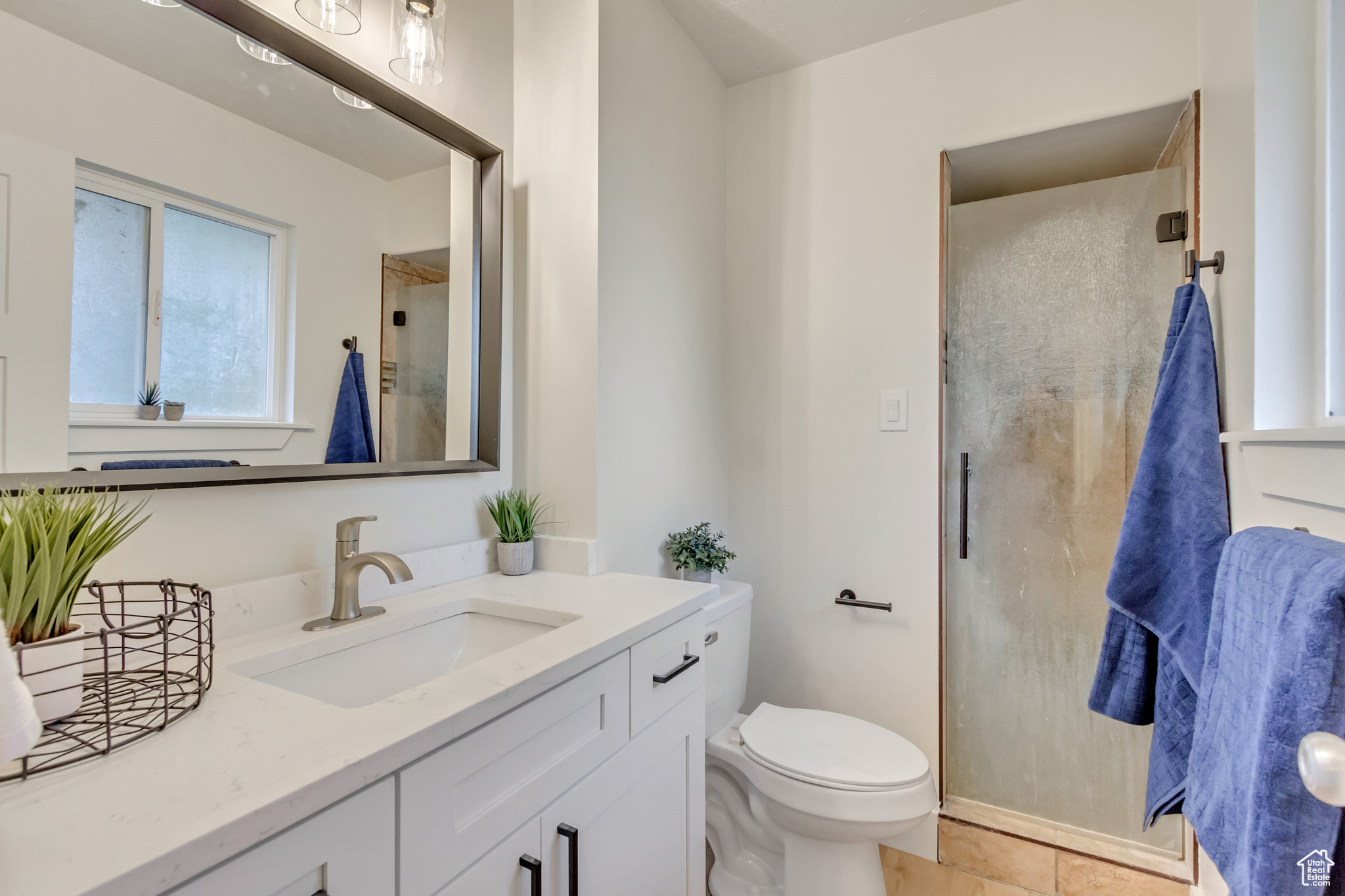 Bathroom with vanity, toilet, tile patterned floors, and an enclosed shower