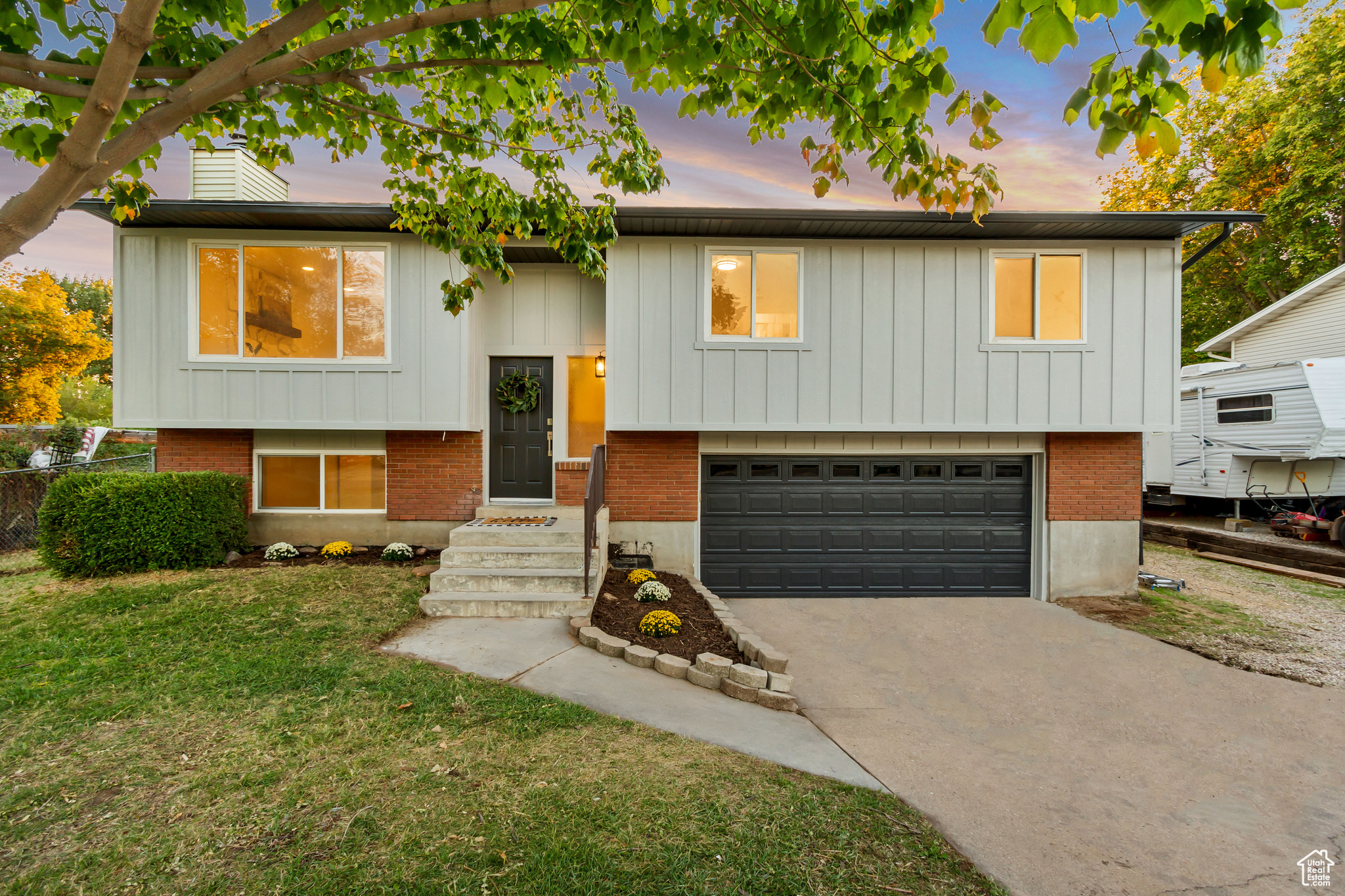 Raised ranch featuring a garage and a yard