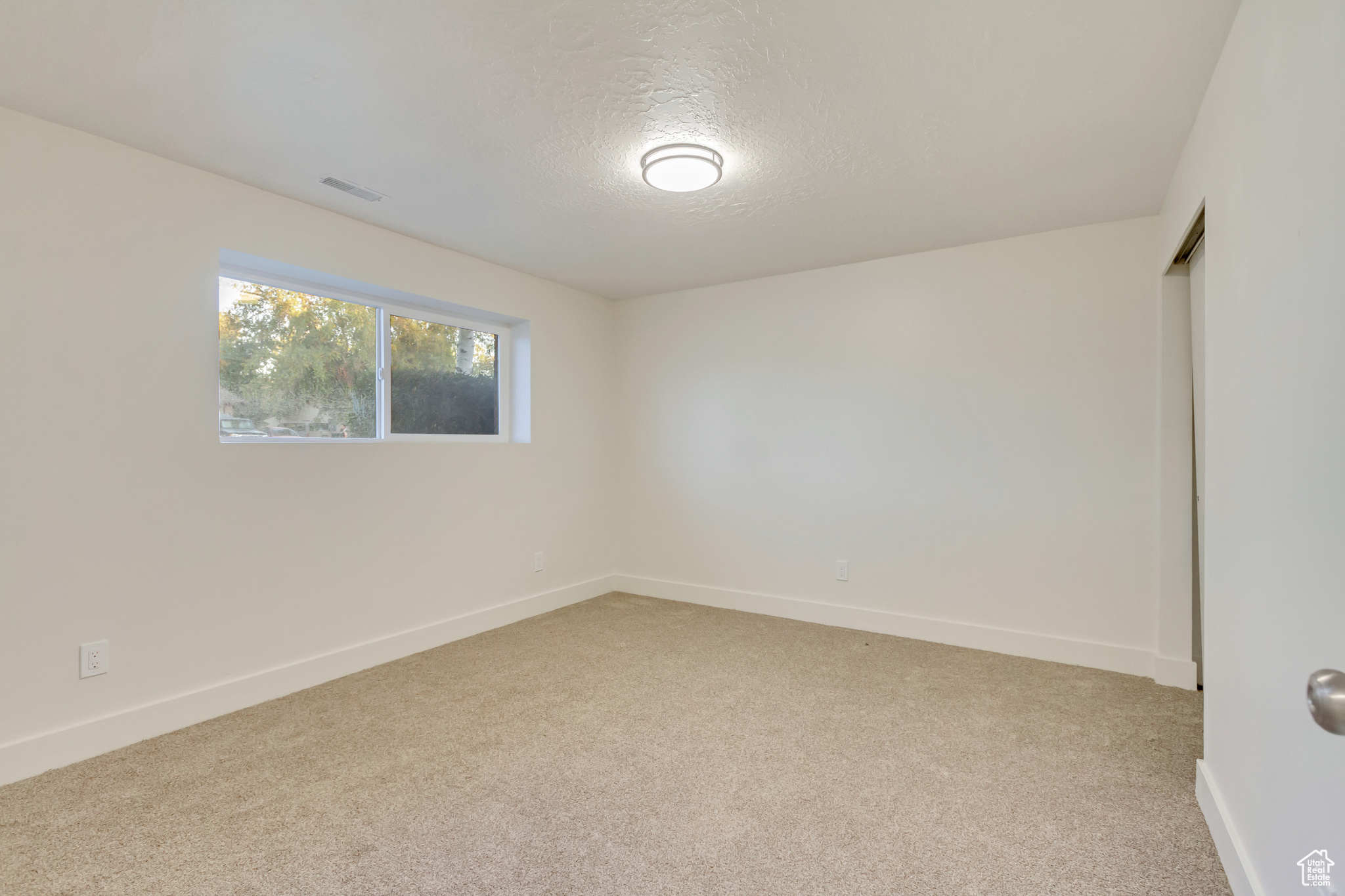 Unfurnished room featuring a textured ceiling and carpet flooring