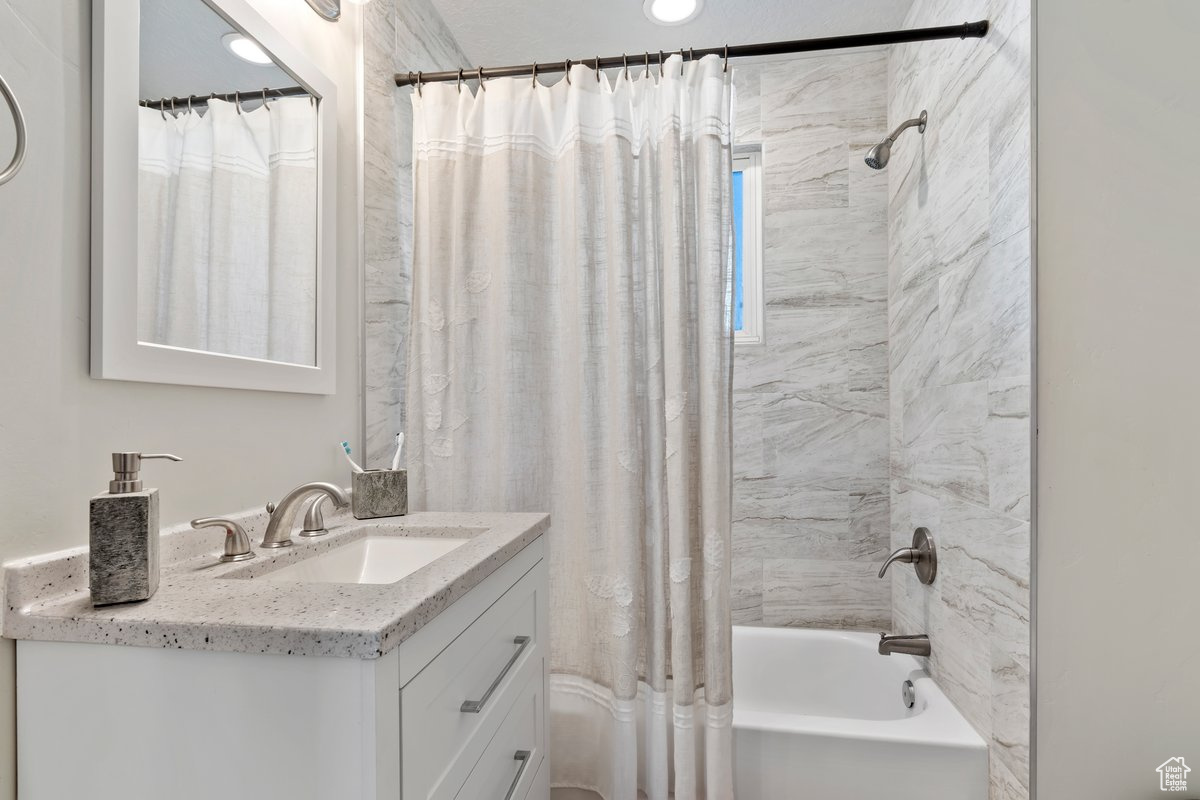 Bathroom featuring vanity and shower / bath combo with shower curtain