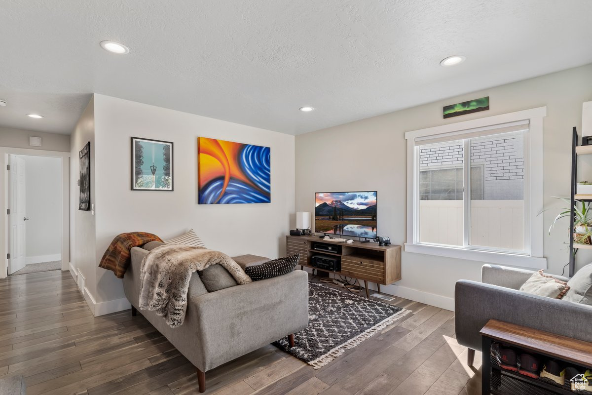 Living room featuring a textured ceiling and dark wood-type flooring