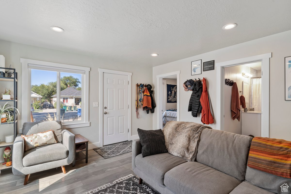 Living room with a textured ceiling and light hardwood / wood-style flooring