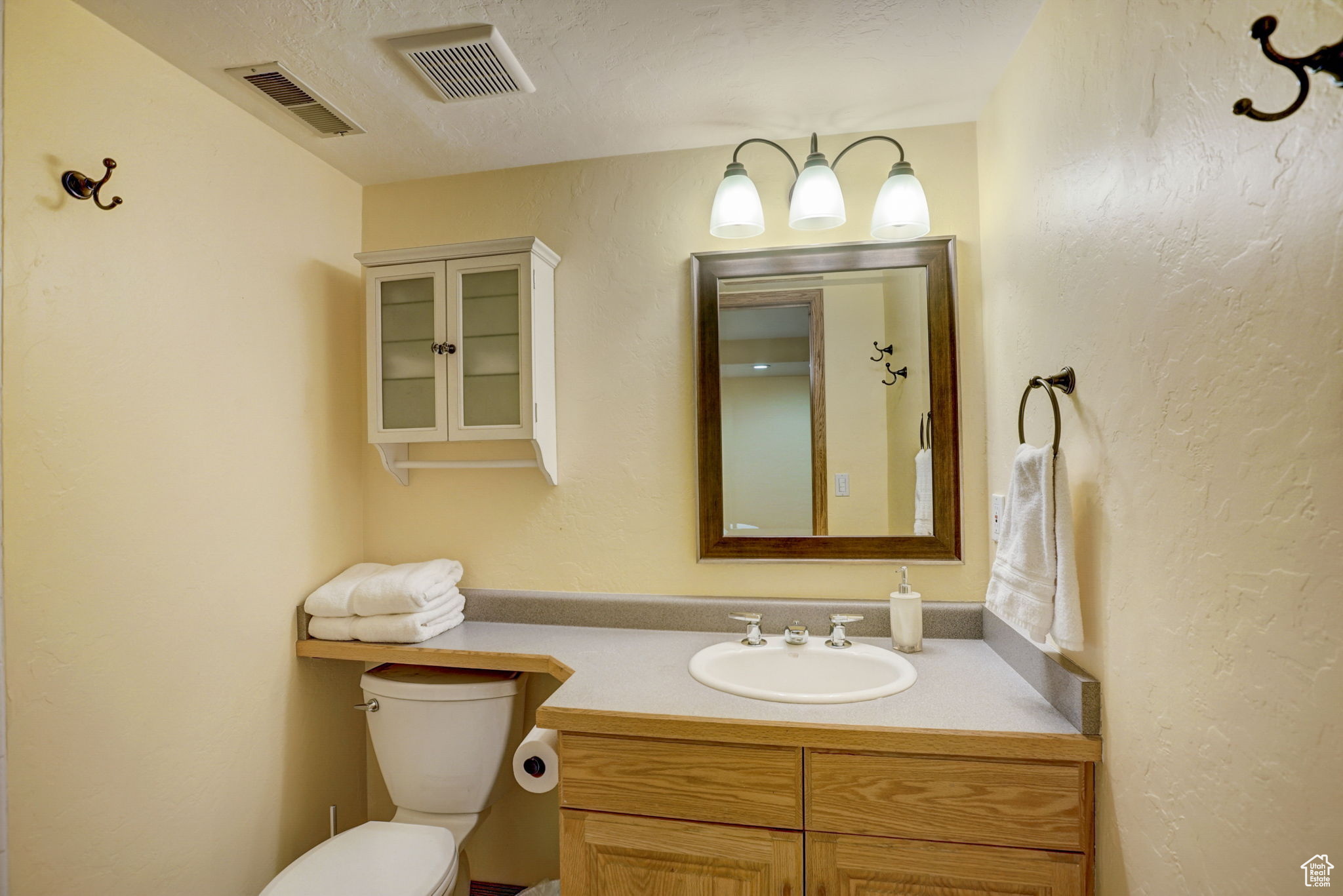 Bathroom featuring a textured ceiling, vanity, and toilet