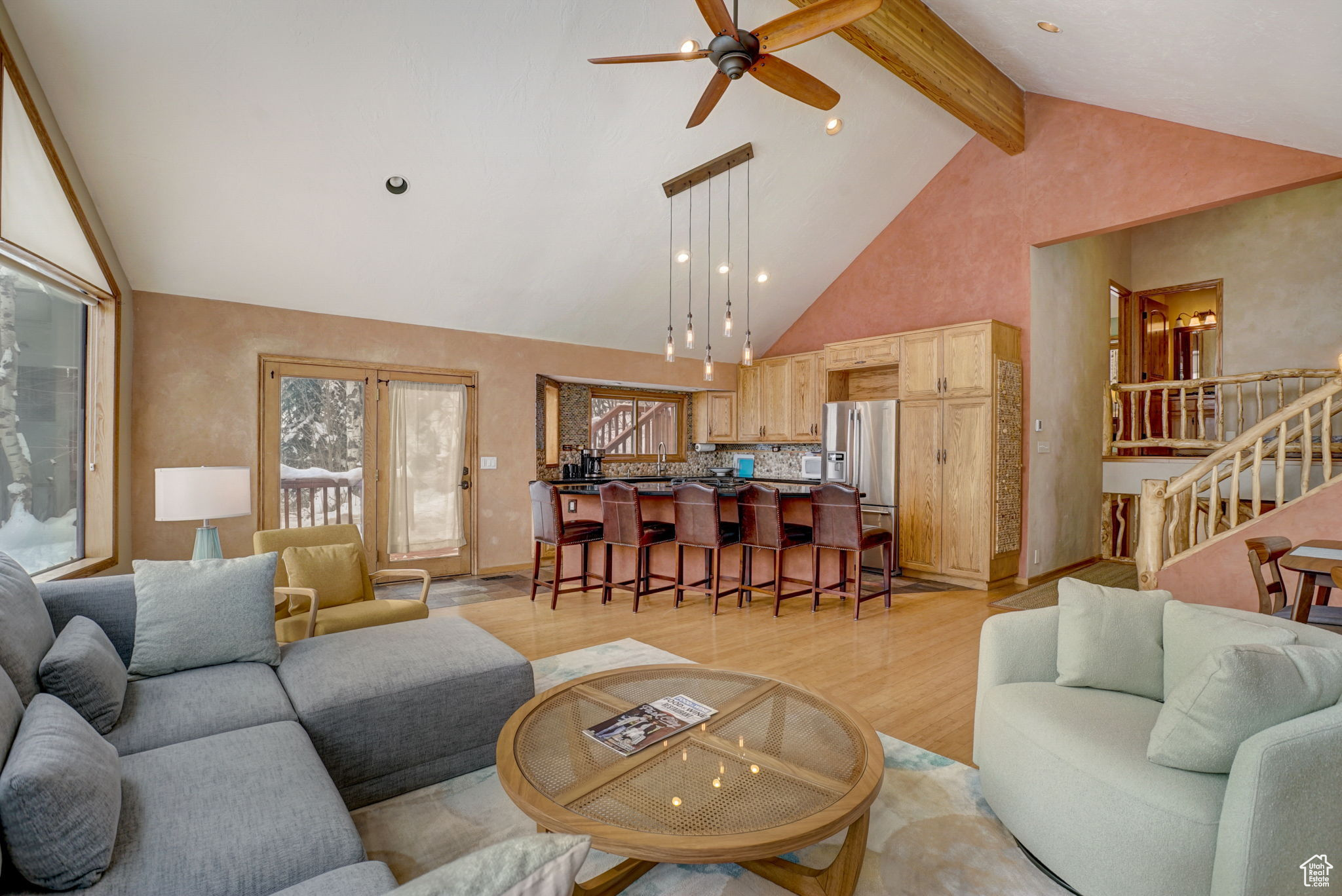 Living room with light hardwood / wood-style flooring, beam ceiling, ceiling fan, and high vaulted ceiling