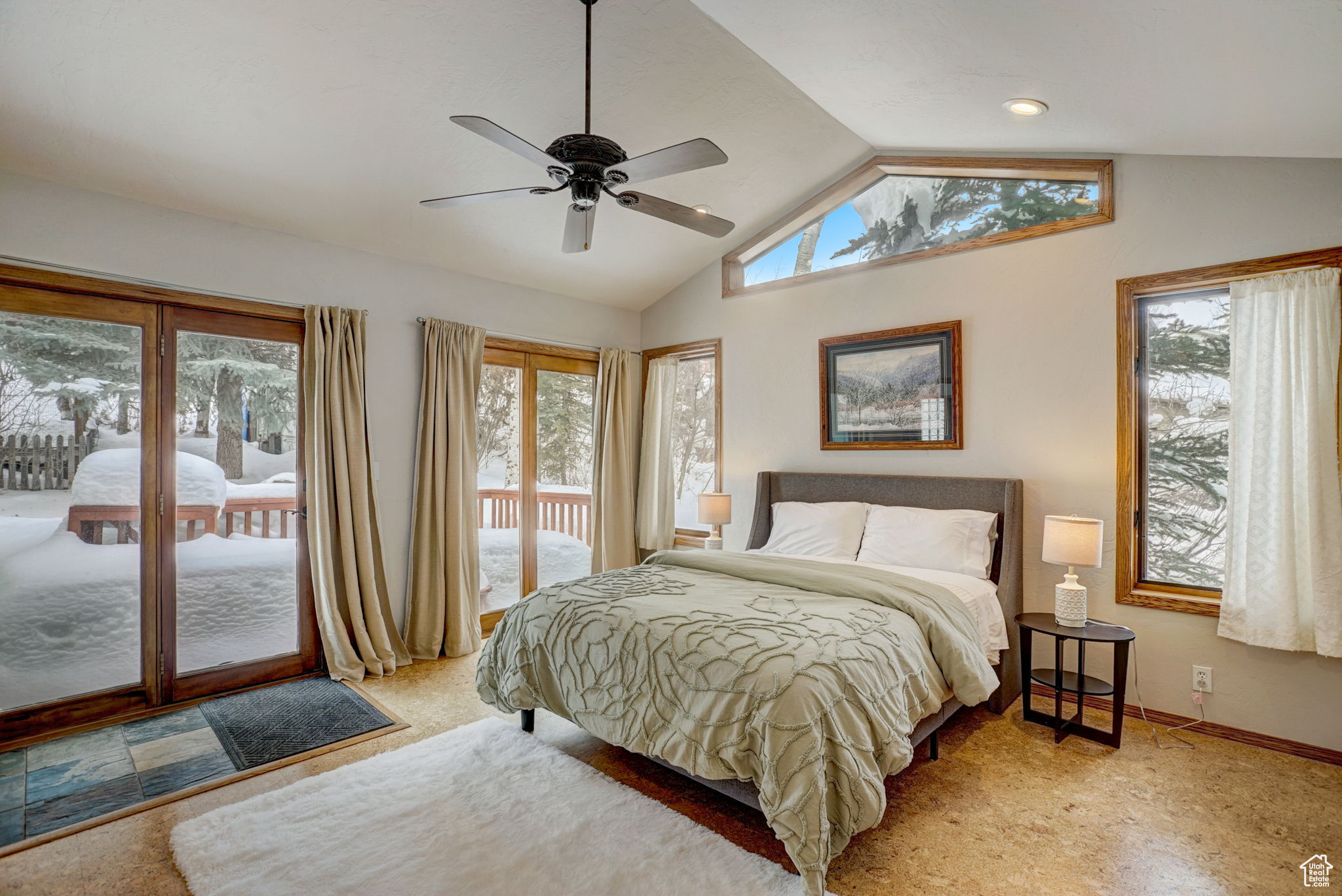 Carpeted bedroom with ceiling fan, lofted ceiling, and access to exterior