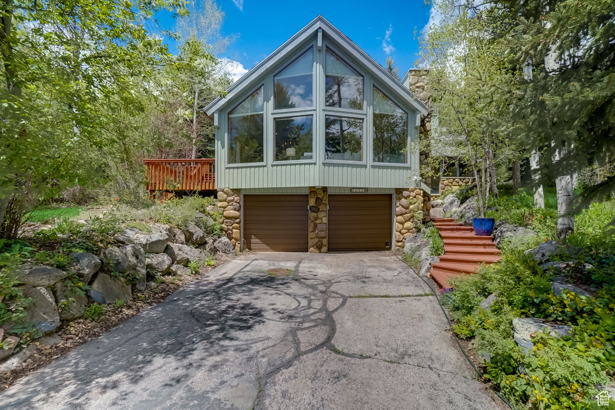 View of property exterior featuring a garage and a deck