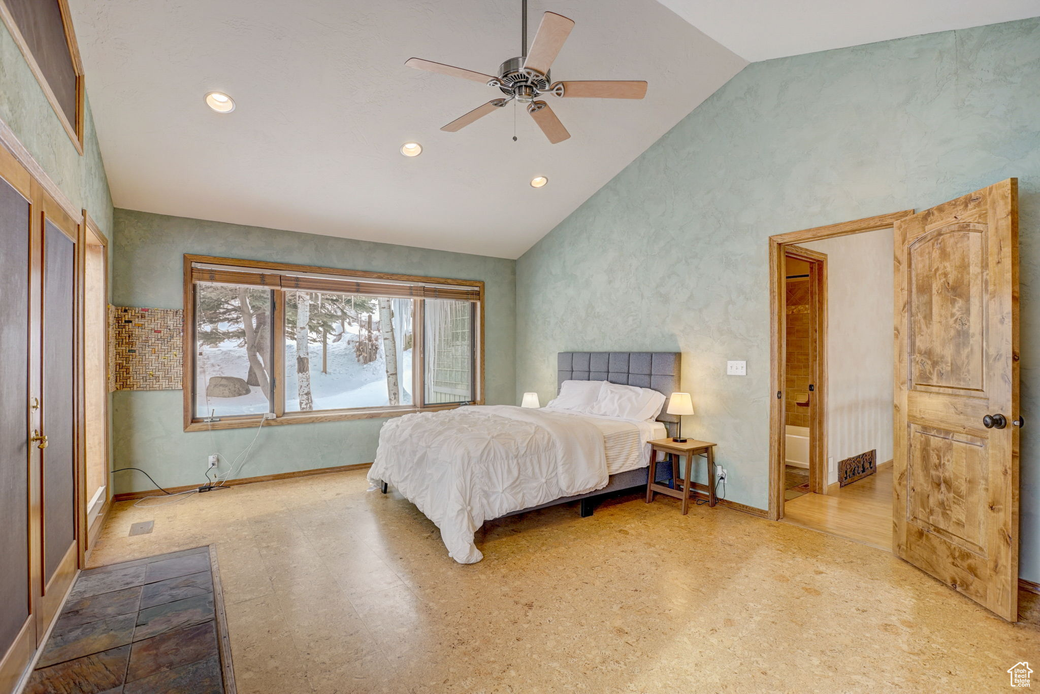 Bedroom with connected bathroom, vaulted ceiling, and ceiling fan