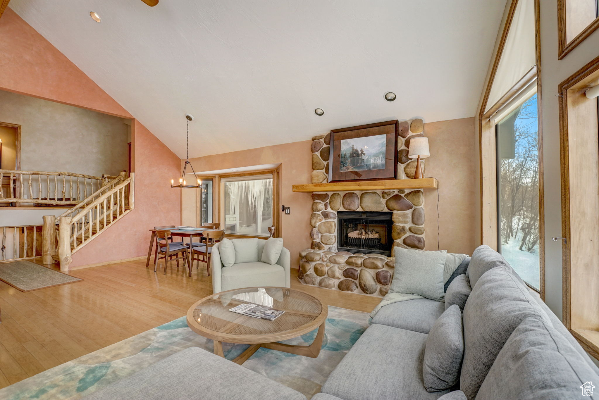 Living room featuring wood-type flooring, a fireplace, and a chandelier