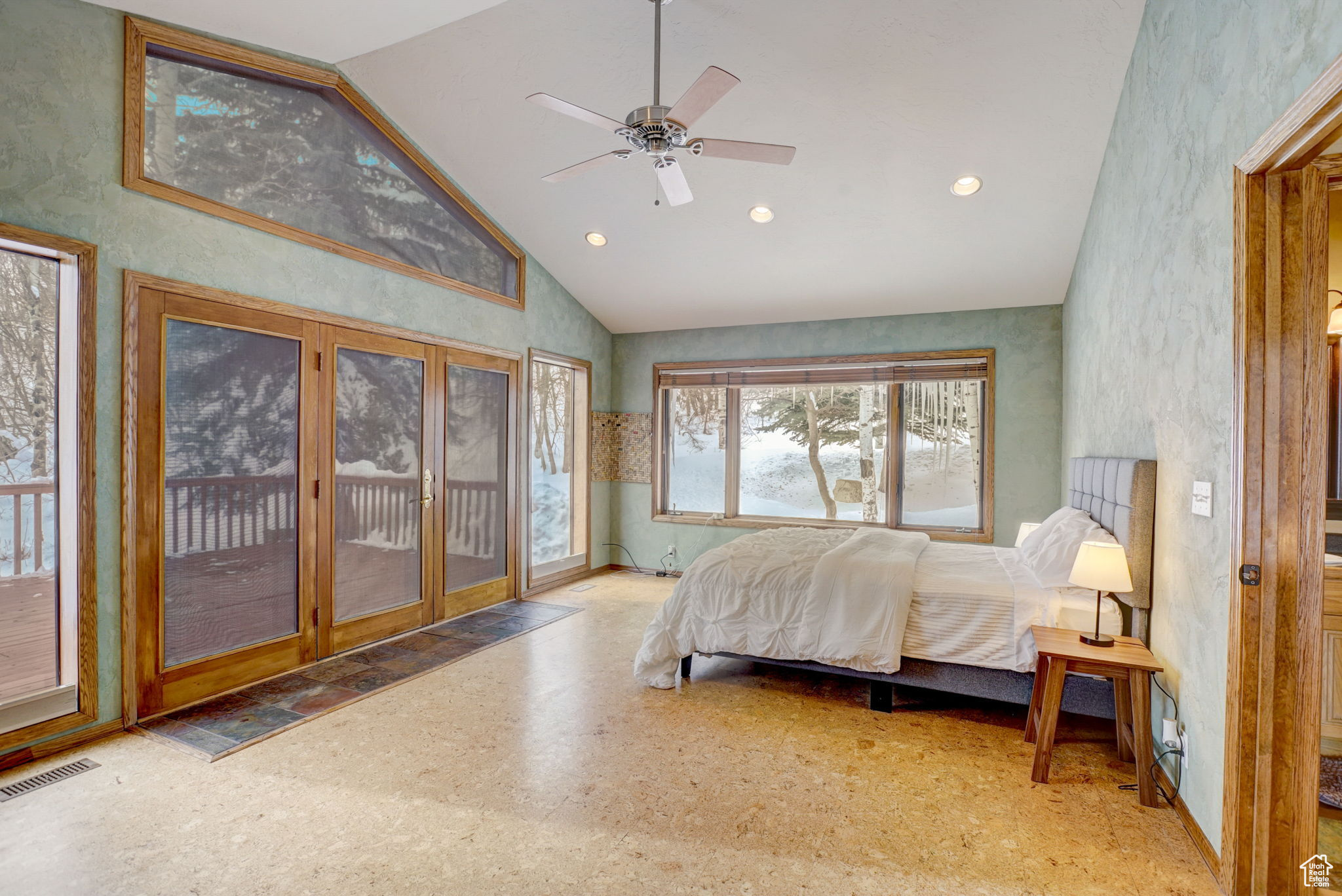 Bedroom with high vaulted ceiling, ceiling fan, and access to exterior