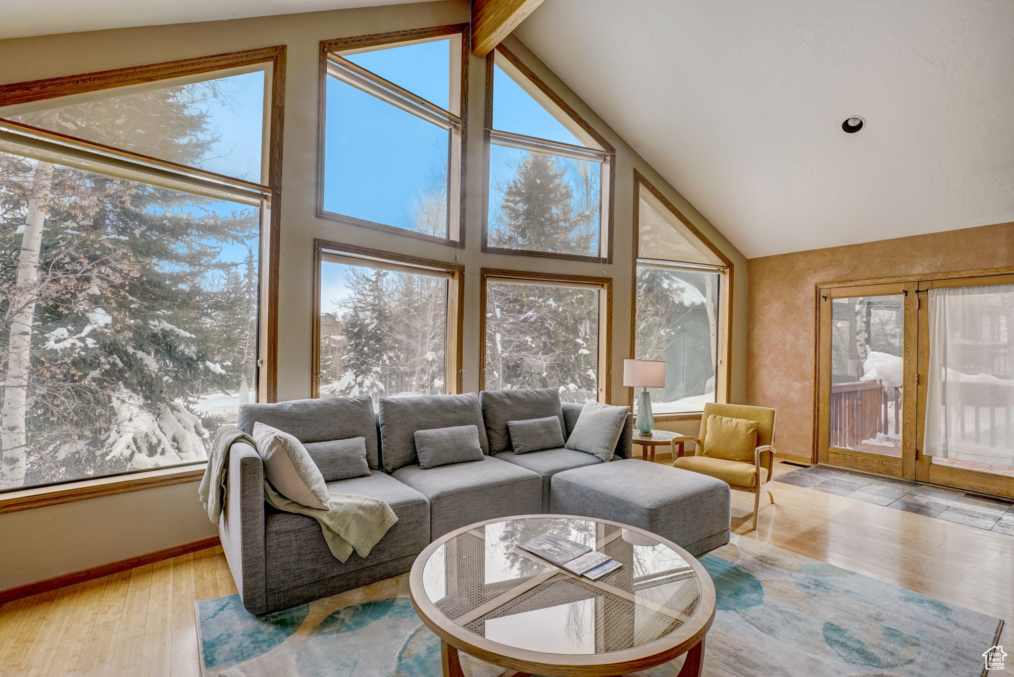 Living room with high vaulted ceiling, light hardwood / wood-style floors, and beamed ceiling