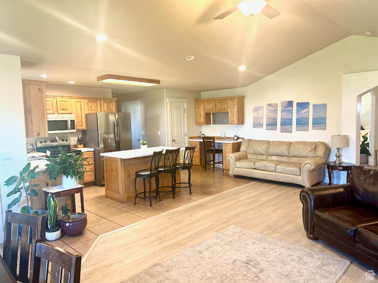 Living room with light hardwood / wood-style floors, lofted ceiling, and ceiling fan