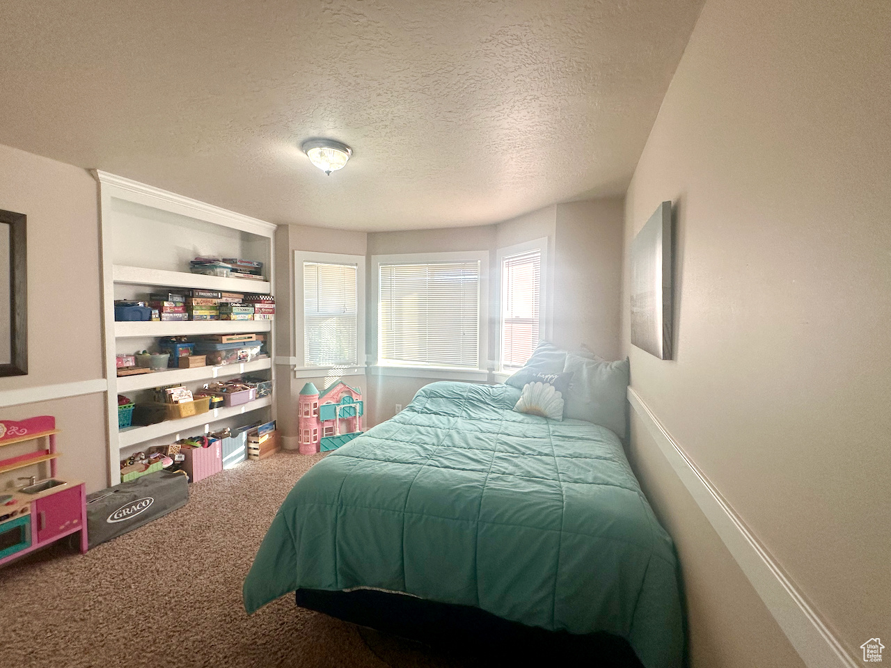 Carpeted bedroom with a textured ceiling