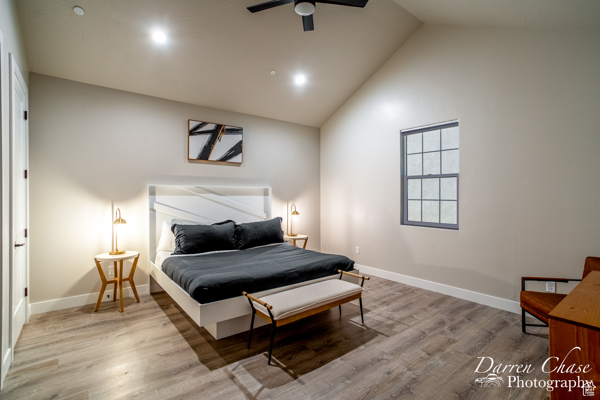 Bedroom with high vaulted ceiling, ceiling fan, and hardwood / wood-style floors