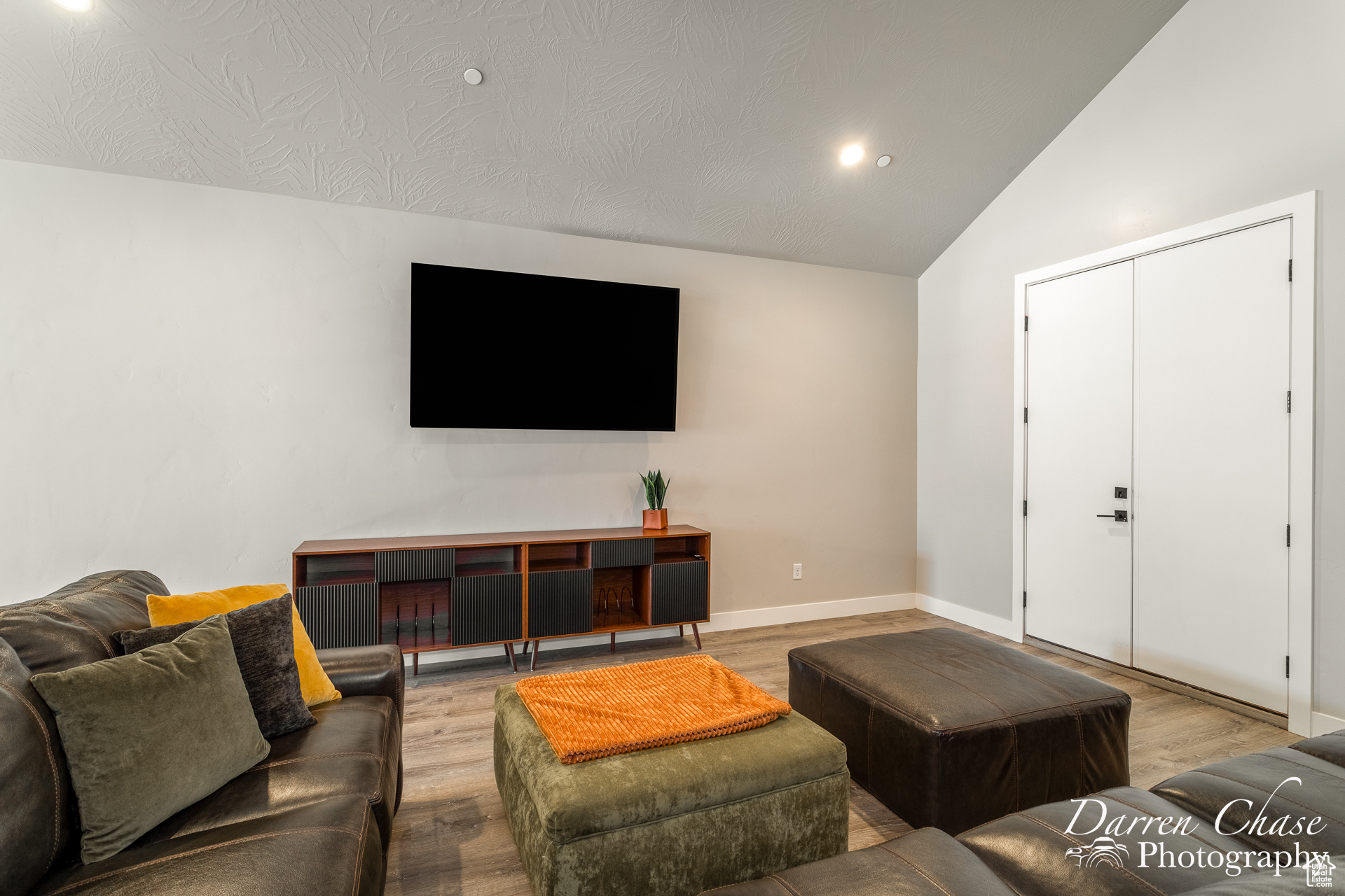 Living room with light hardwood / wood-style flooring and high vaulted ceiling