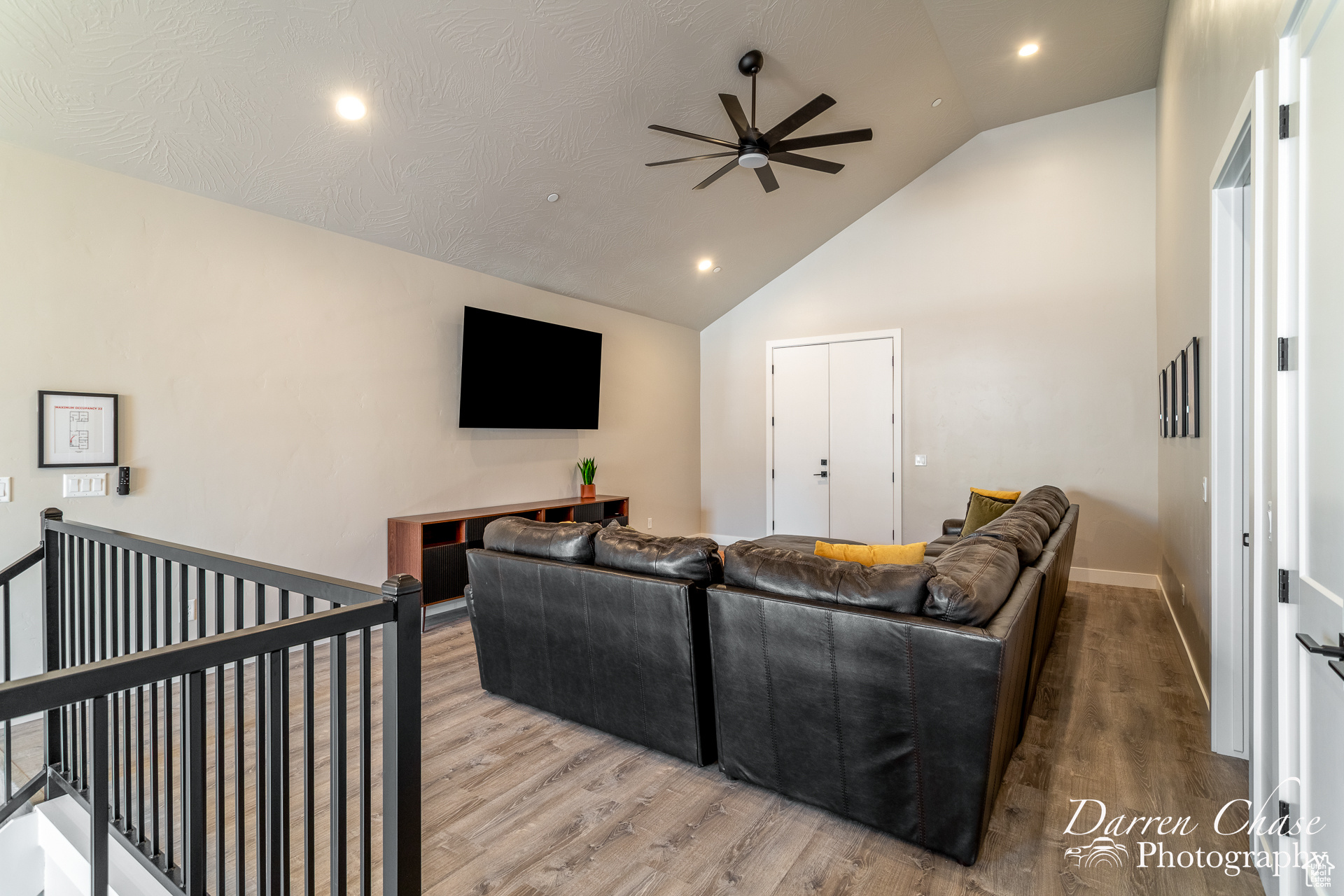 Living room featuring hardwood / wood-style floors, ceiling fan, and high vaulted ceiling