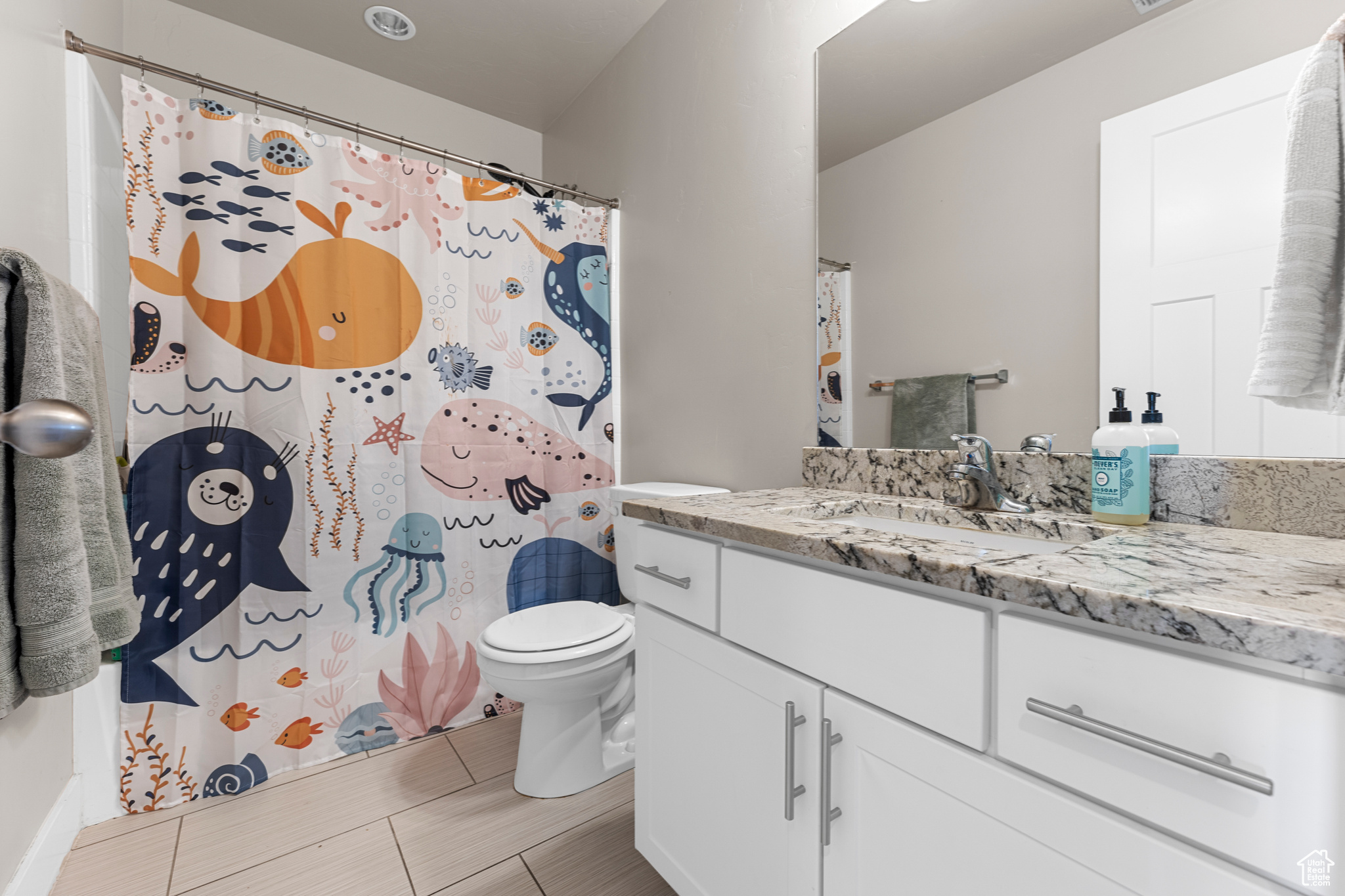 Bathroom featuring vanity, toilet, and a shower with shower curtain