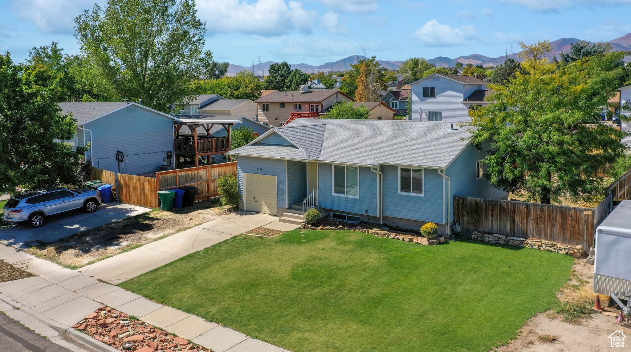 View of front of house featuring a front yard, a mountain view, and a garage