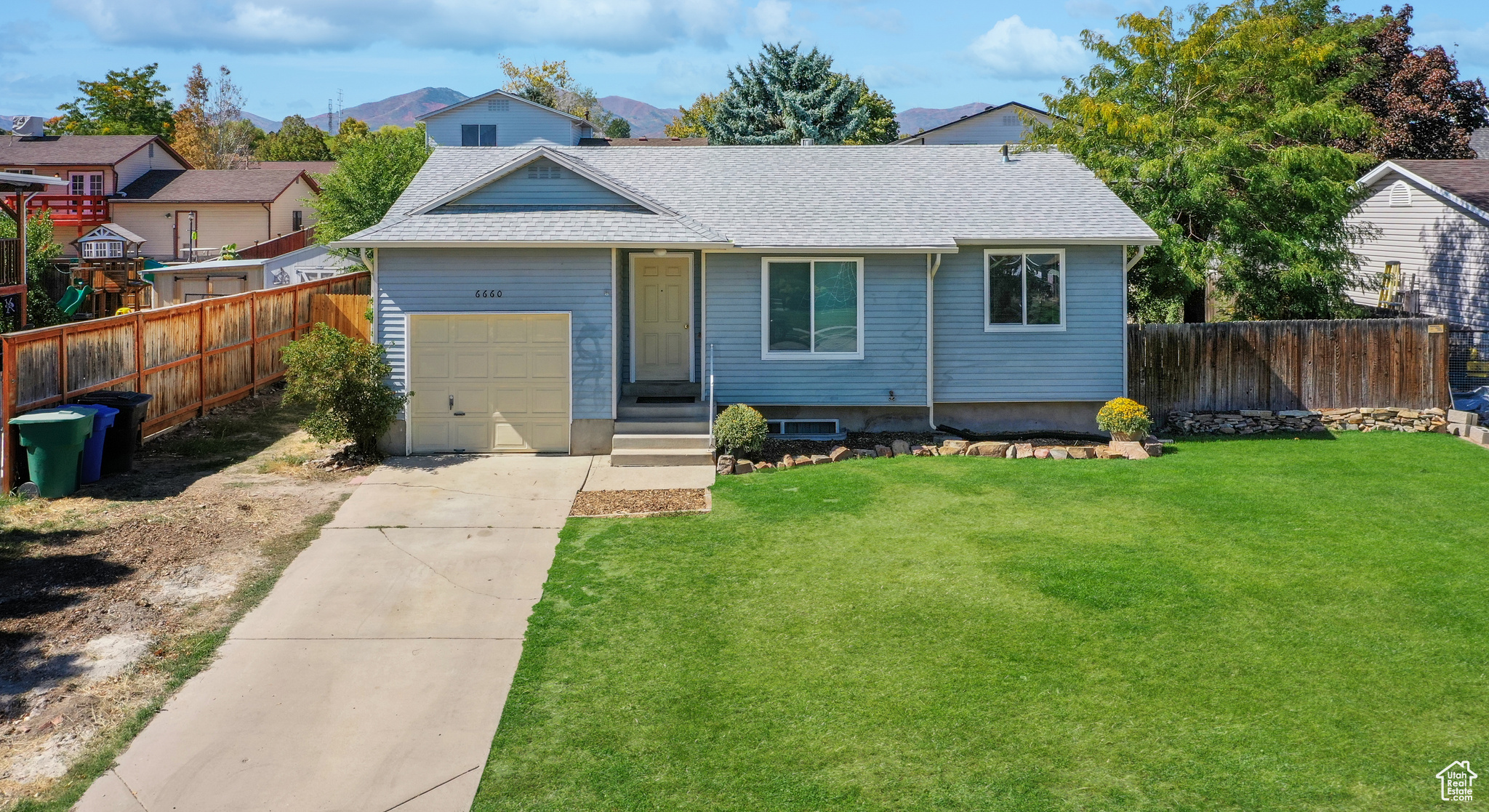 View of front facade with a garage, a mountain view, and a front yard