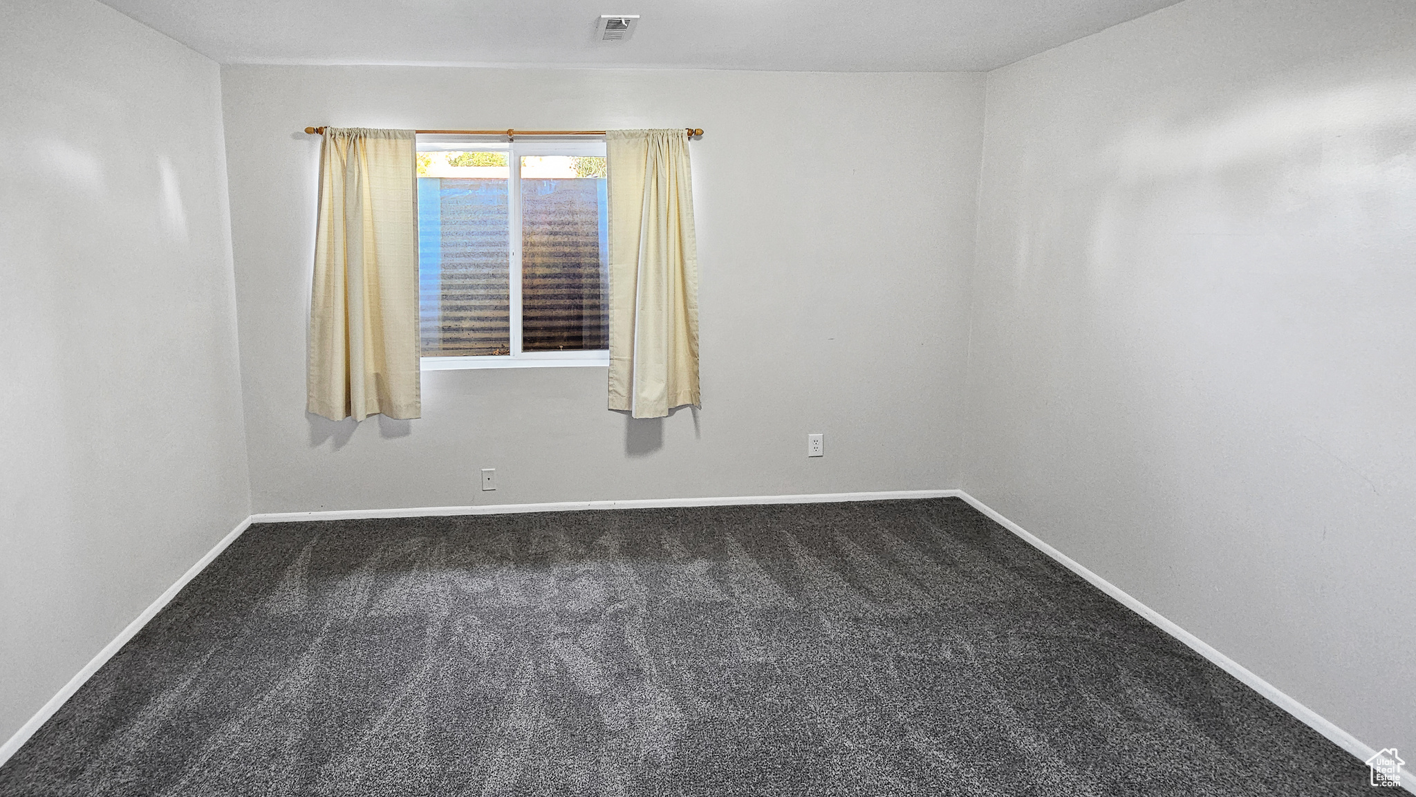 Spare room with dark carpet