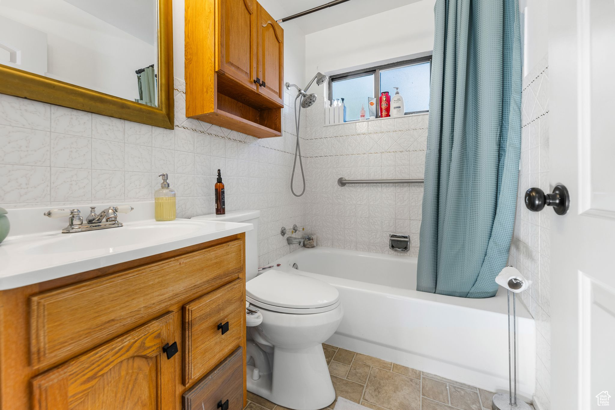 Full bathroom featuring shower / bath combination with curtain, vanity, toilet, tasteful backsplash, and tile patterned flooring