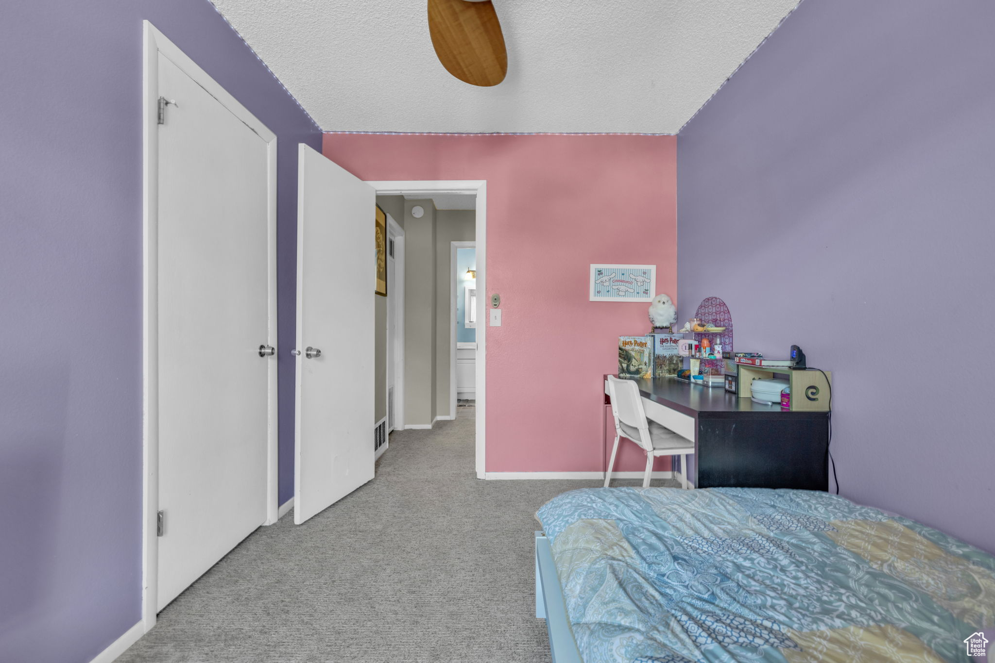 Carpeted bedroom with a textured ceiling and ceiling fan