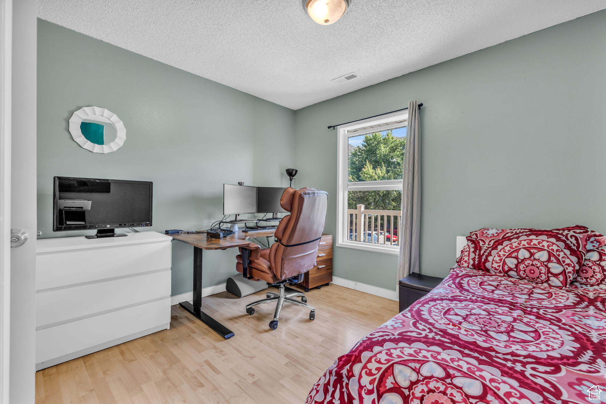 Bedroom featuring a textured ceiling and light hardwood / wood-style floors