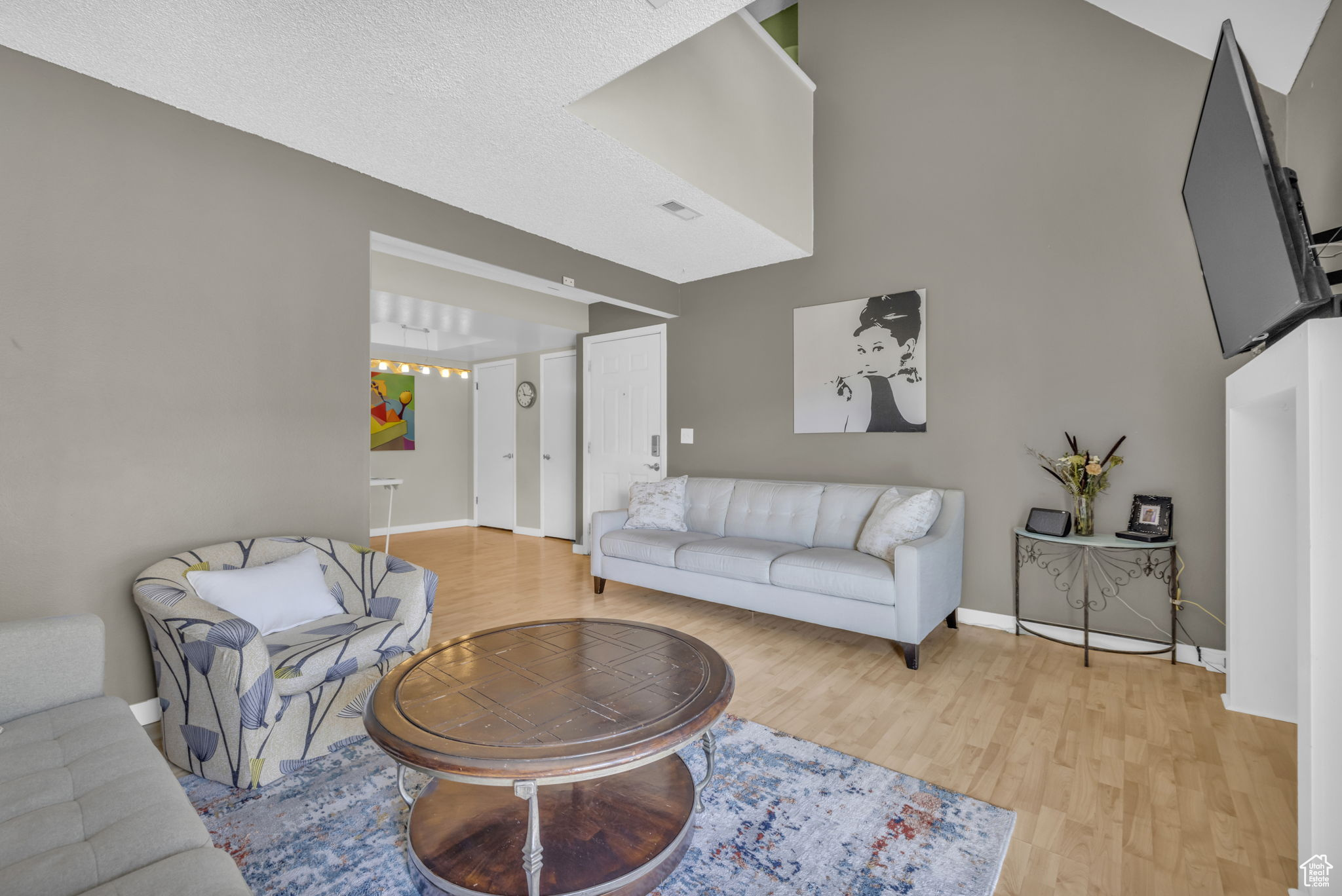 Living room featuring a textured ceiling and light hardwood / wood-style flooring