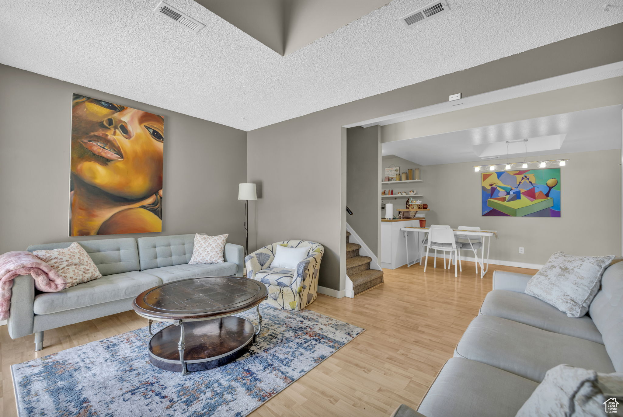 Living room with a textured ceiling and hardwood / wood-style floors