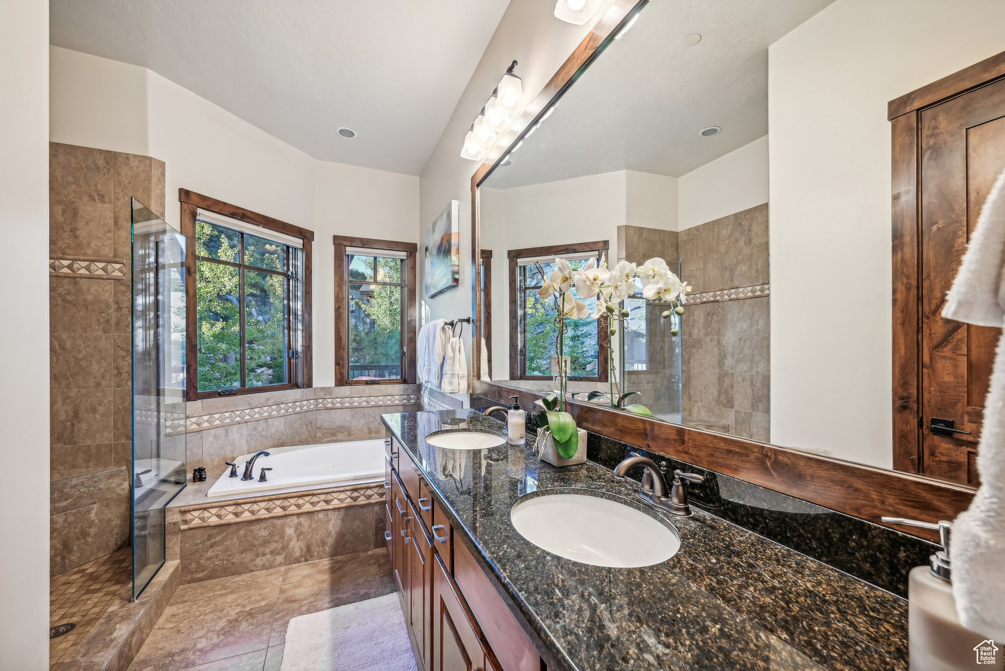 Bathroom with tile patterned floors, vanity, and separate shower and tub