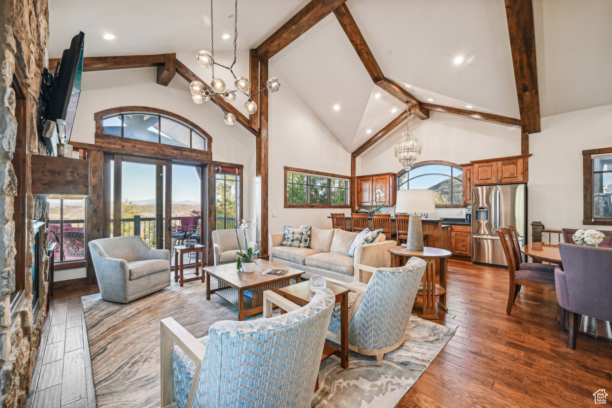 Living room with beam ceiling, dark hardwood / wood-style flooring, a chandelier, and plenty of natural light