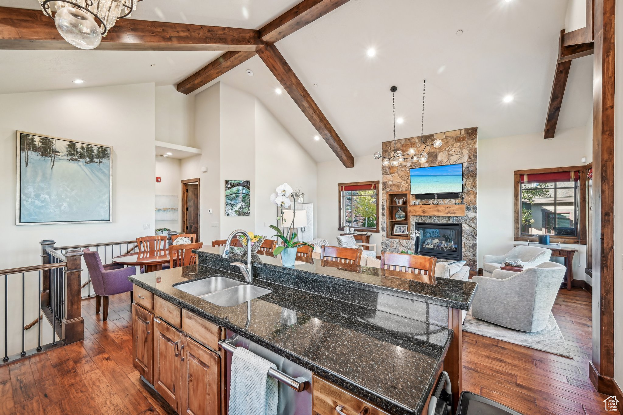 Kitchen with an island with sink, a fireplace, sink, and dark hardwood / wood-style flooring