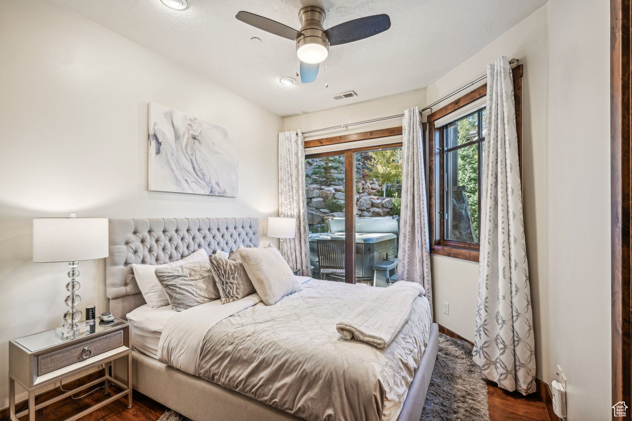 Bedroom with ceiling fan, dark hardwood / wood-style floors, and access to exterior