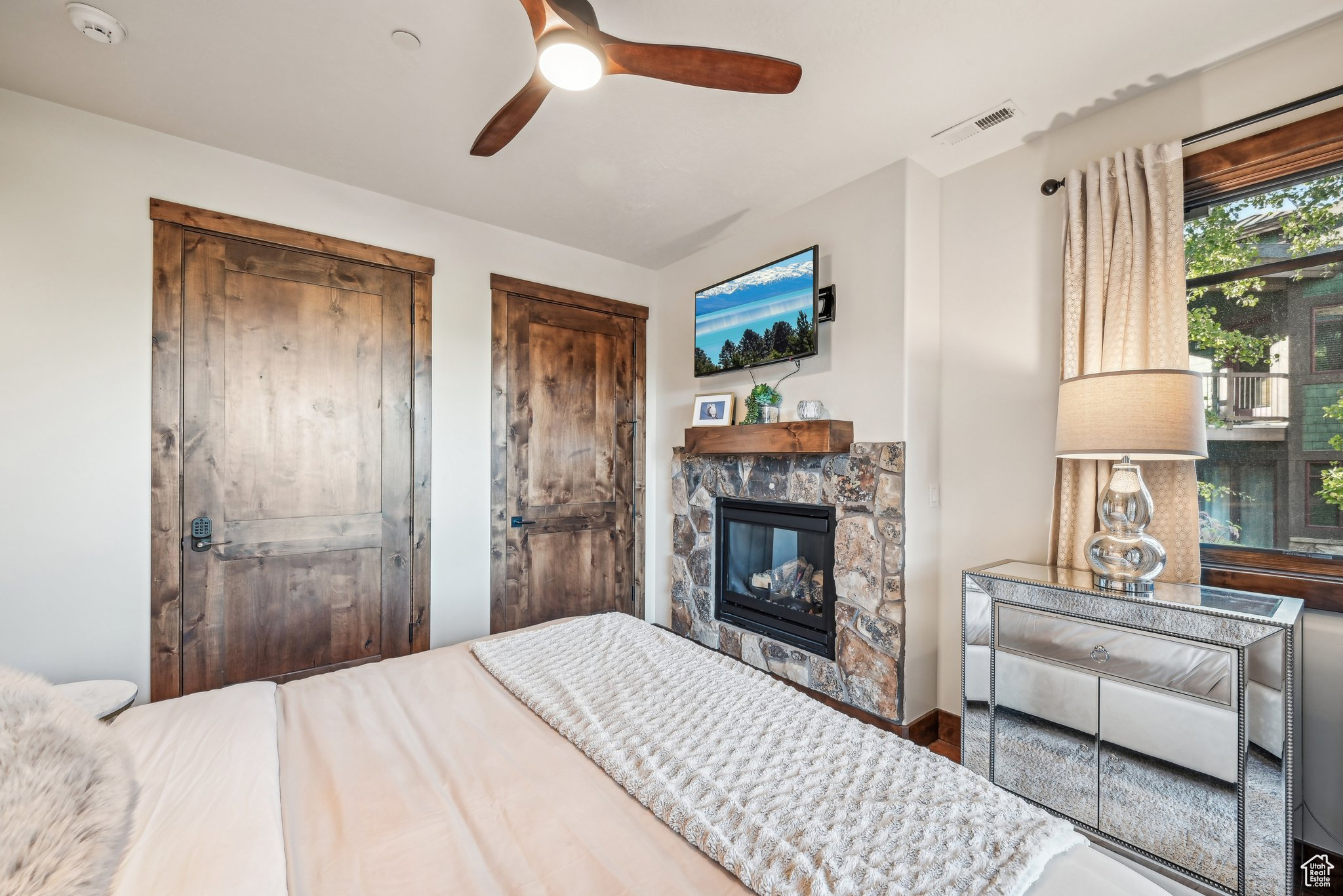 Bedroom featuring multiple closets, ceiling fan, and a fireplace