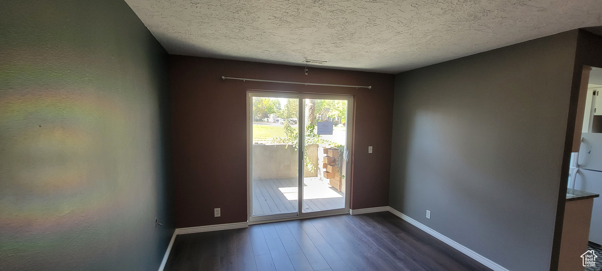 Spare room with a textured ceiling and dark wood-type flooring