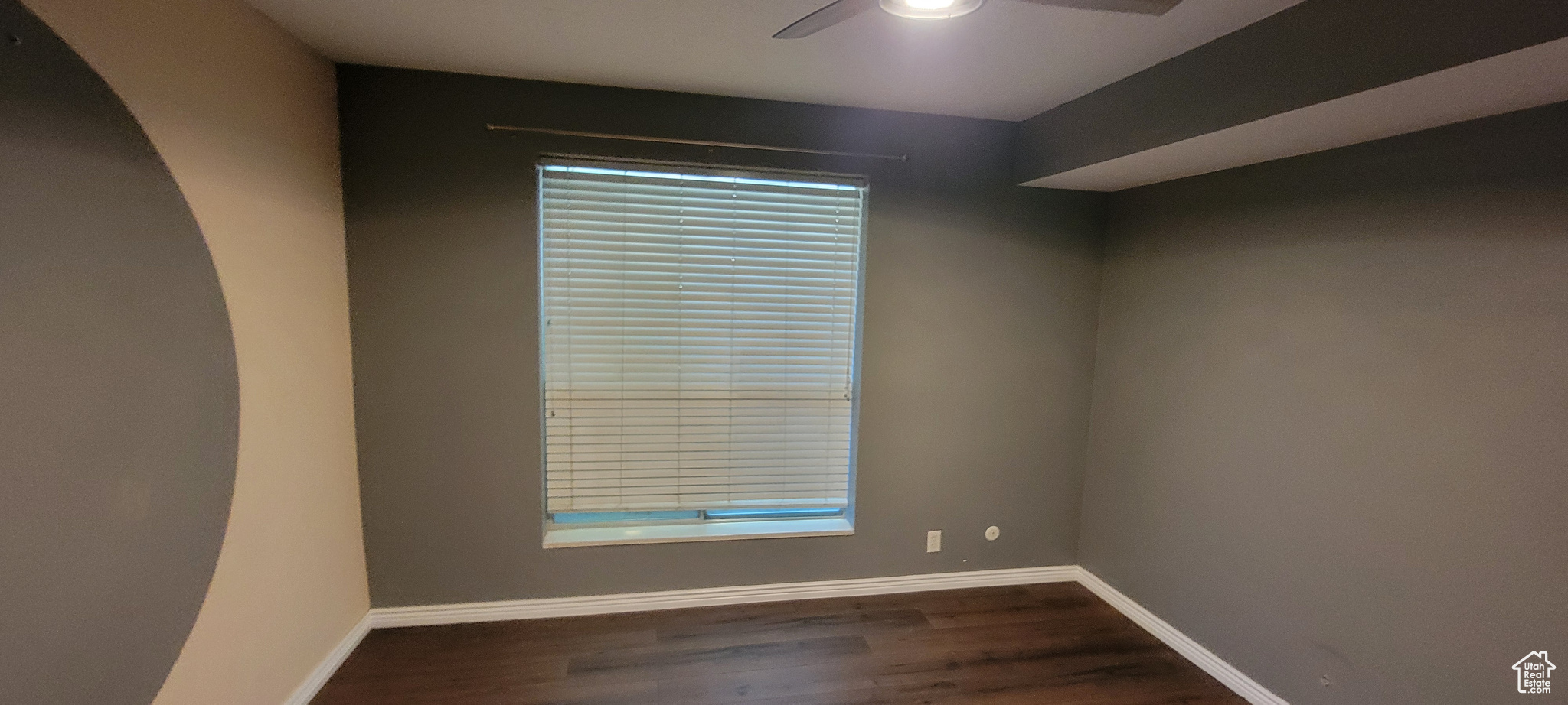 Spare room featuring dark hardwood / wood-style floors and ceiling fan