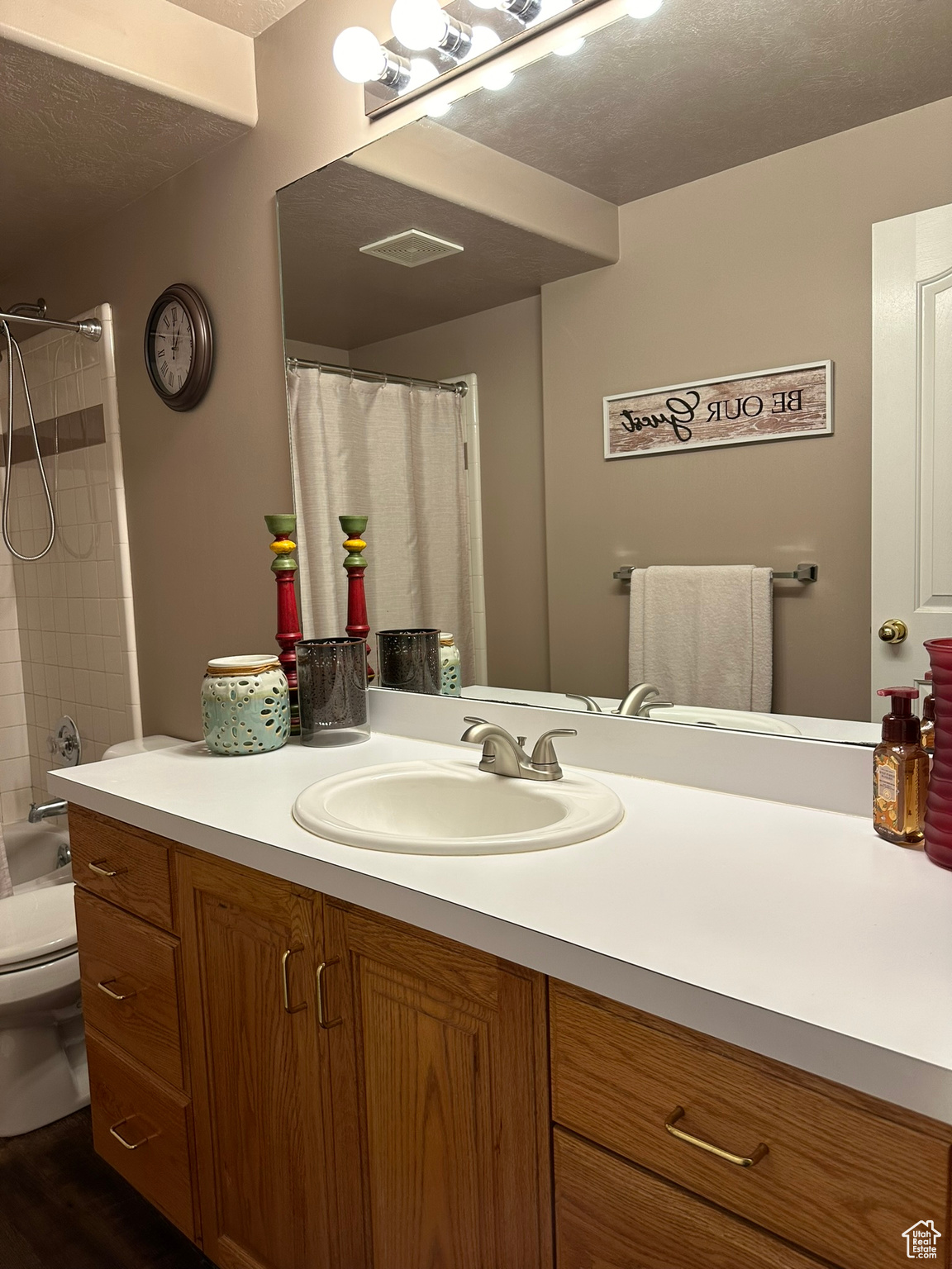 Bathroom with a textured ceiling, hardwood / wood-style flooring, vanity, and toilet