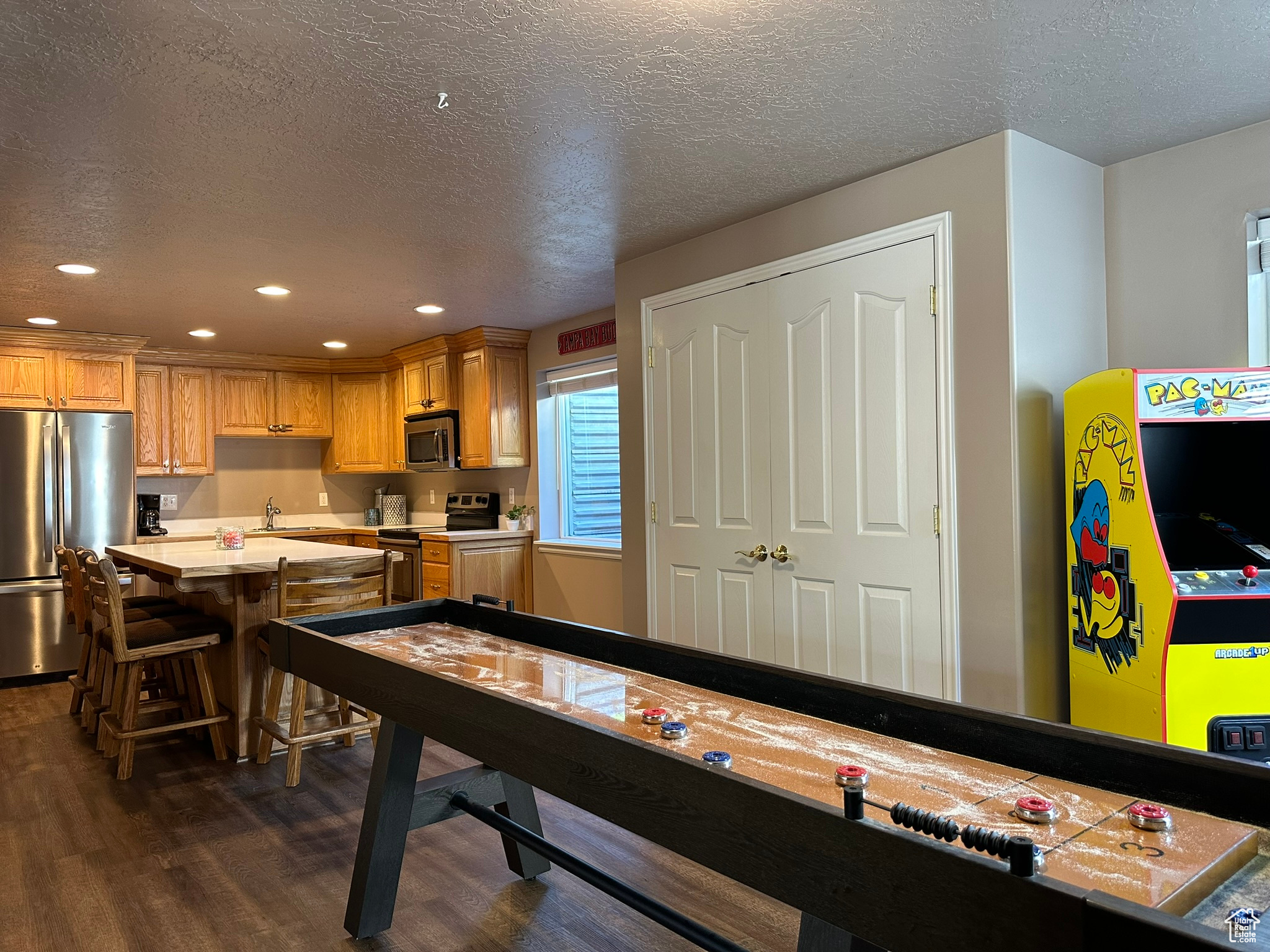 Gameroom with a textured ceiling, dark hardwood / wood-style floors, and sink