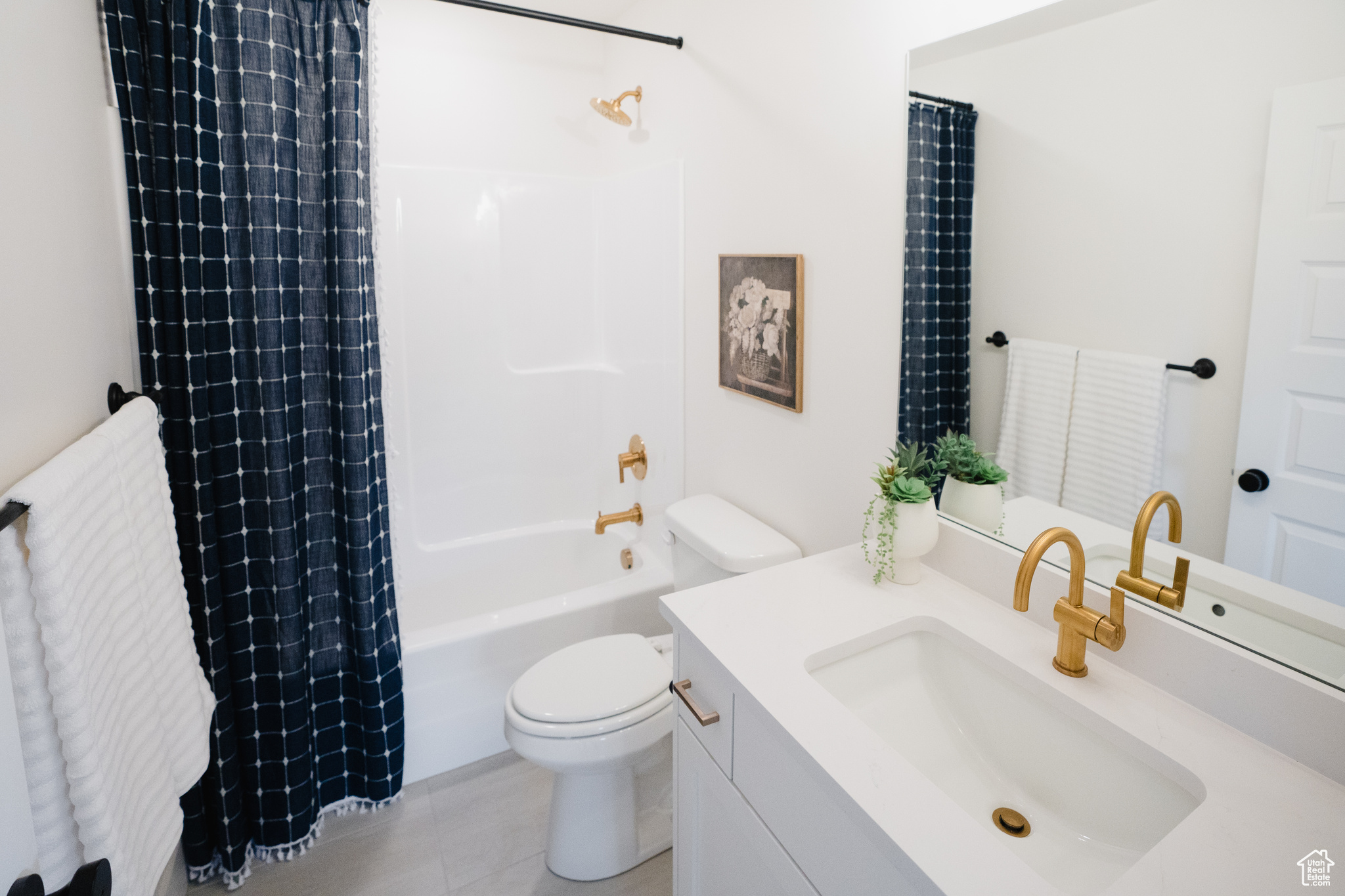 Full bathroom with vanity, toilet, shower / bath combo with shower curtain, and tile patterned floors