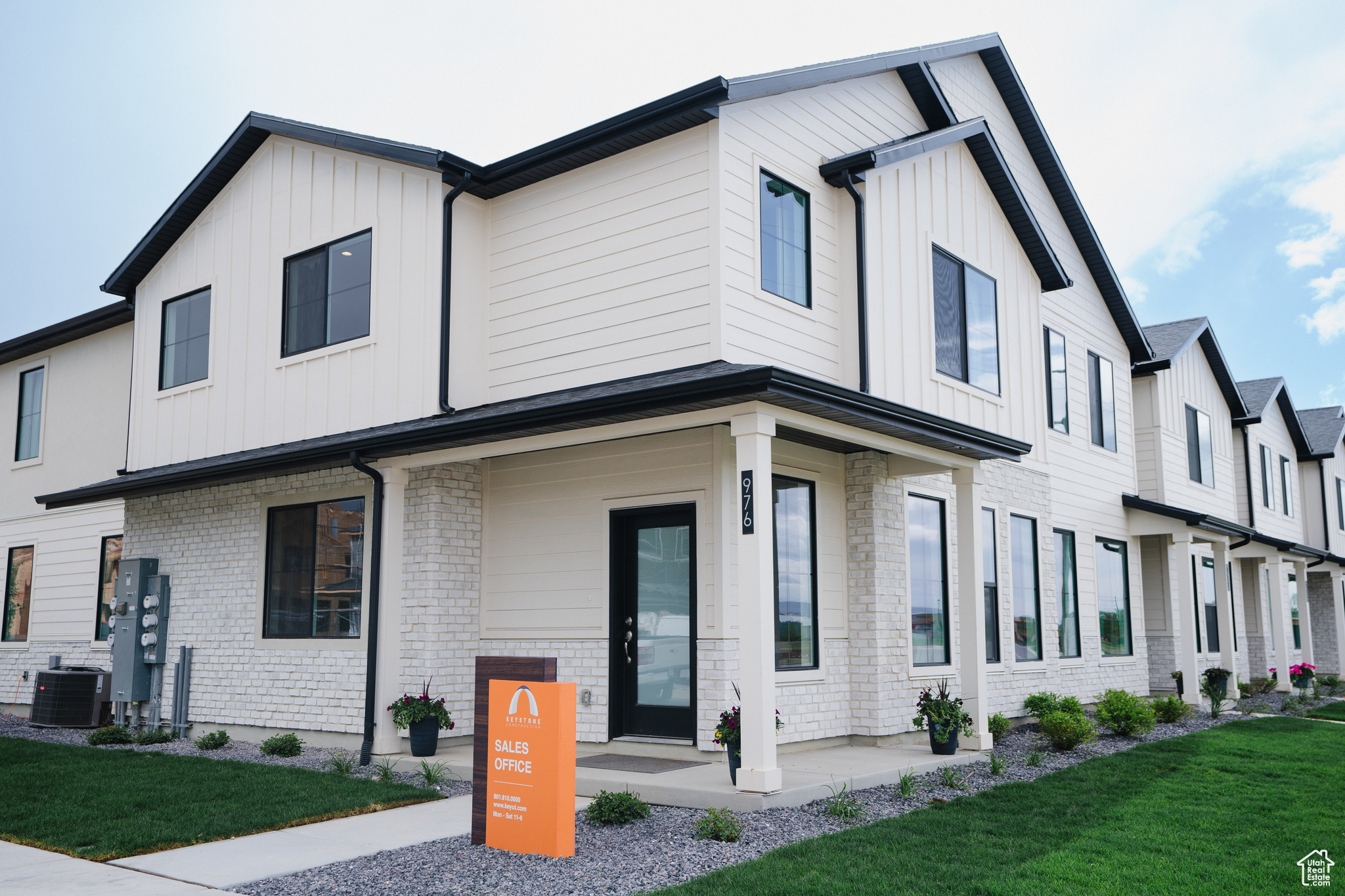 View of front of property featuring central AC unit and a front lawn