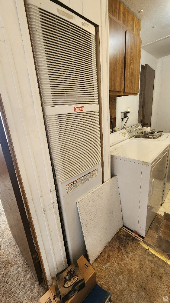 Interior space with cabinets, dark carpet, and washer and dryer