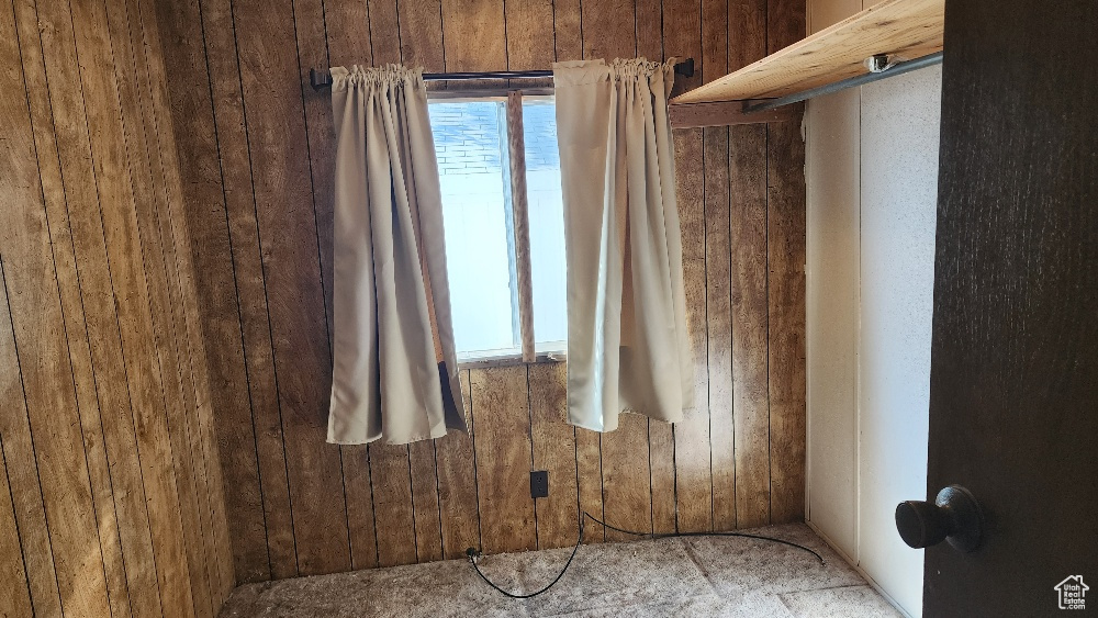 Empty room featuring wood walls