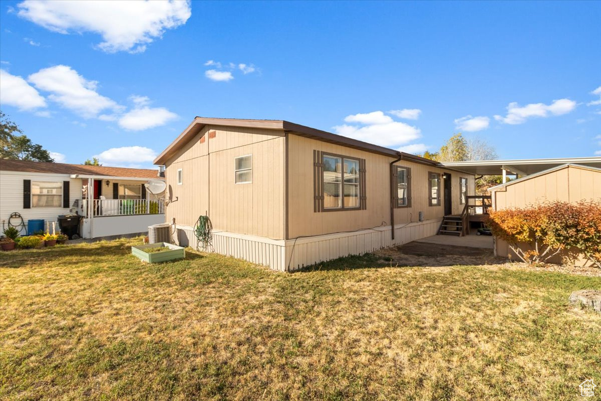 View of property exterior with a yard and central air condition unit