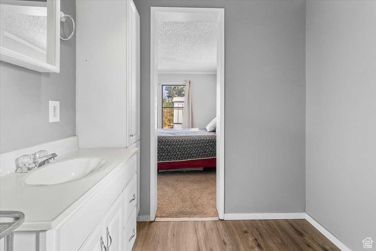 Bathroom featuring wood-type flooring, a textured ceiling, and vanity