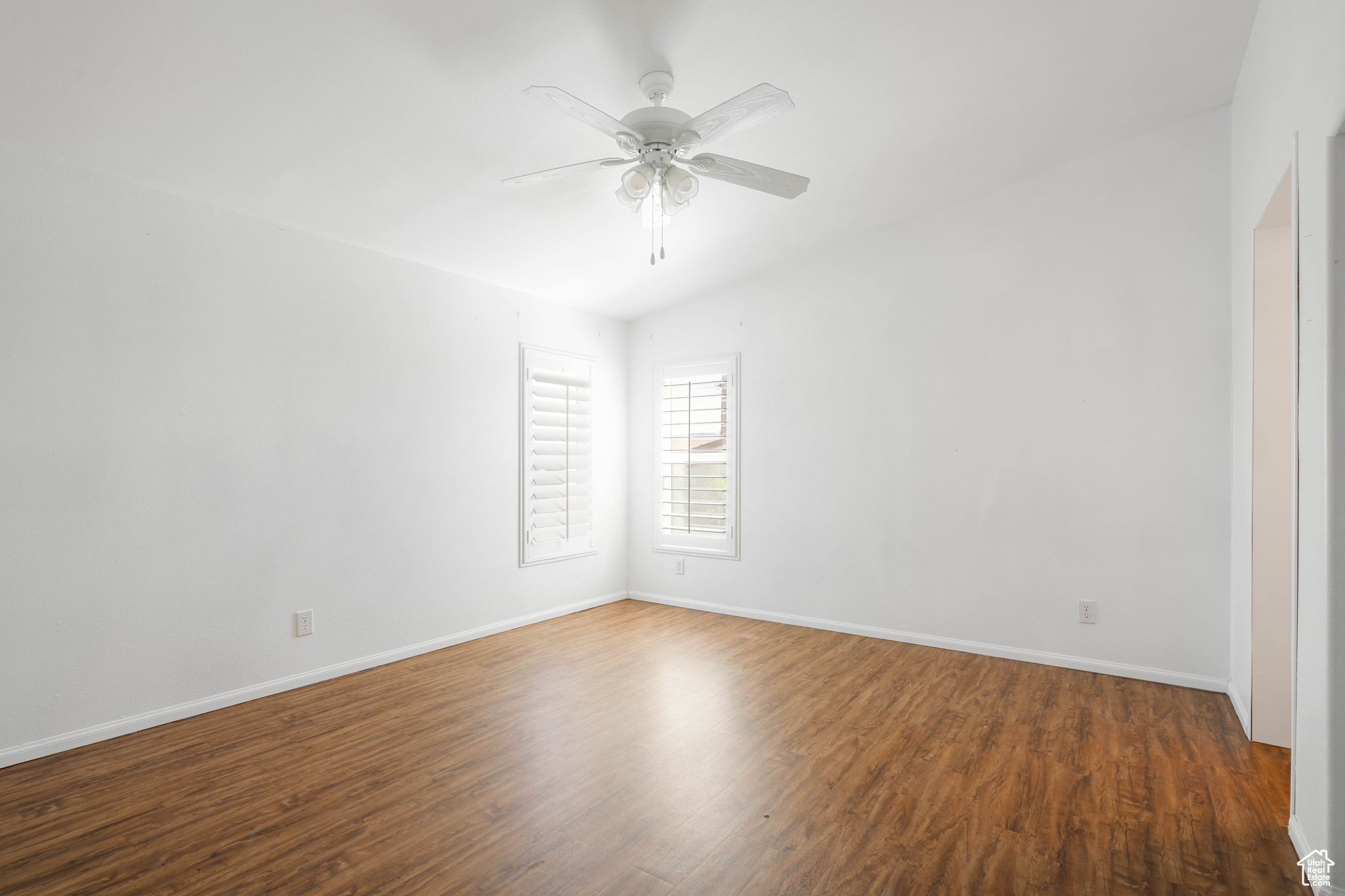 Empty room with vaulted ceiling, ceiling fan, and dark hardwood / wood-style flooring