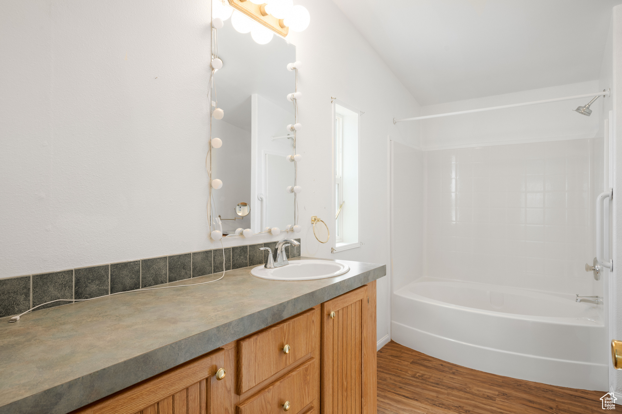 Bathroom featuring bathing tub / shower combination, vanity, and hardwood / wood-style flooring