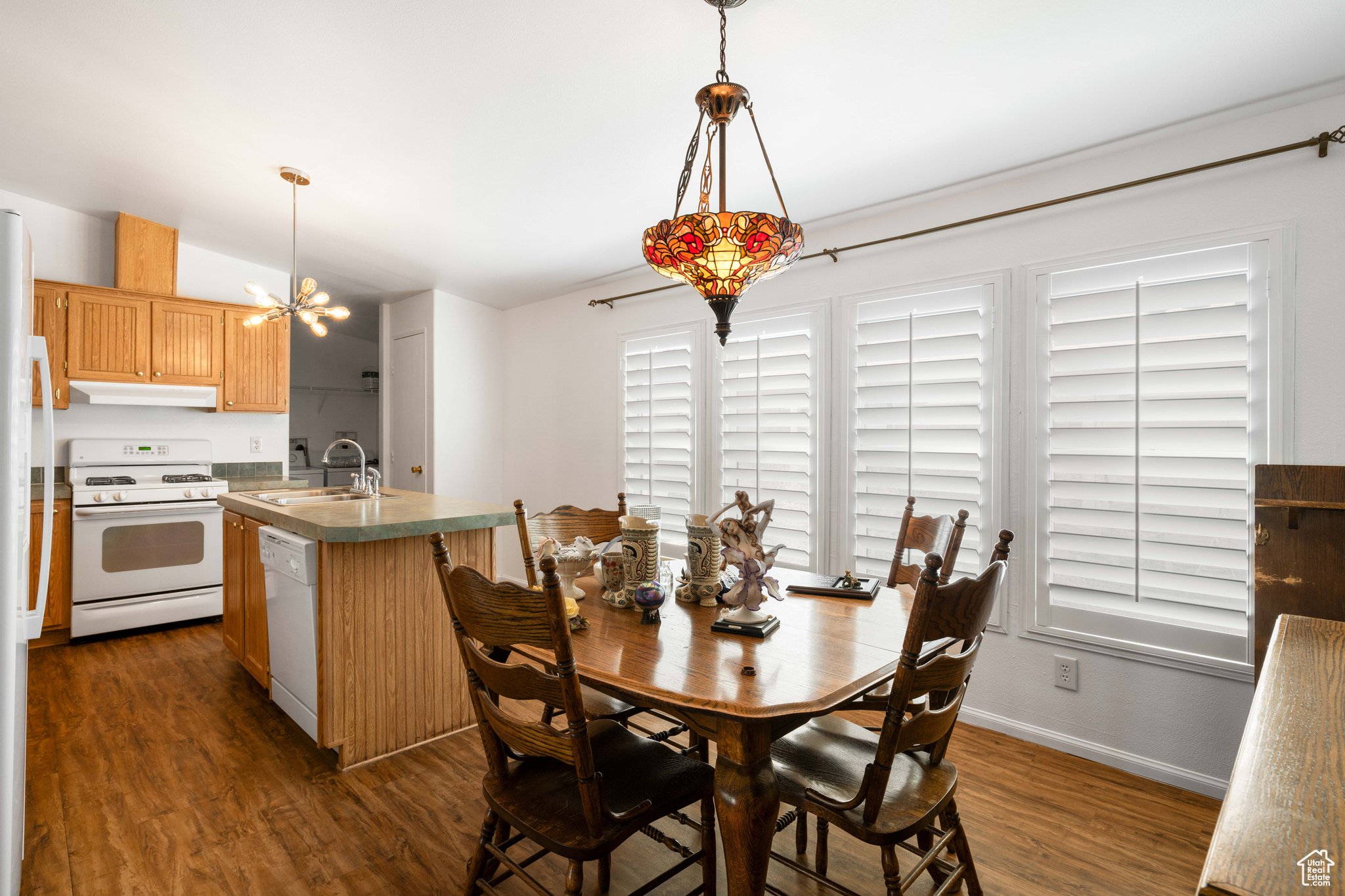 Dining space featuring vaulted ceiling, dark hardwood / wood-style floors, a chandelier, and sink